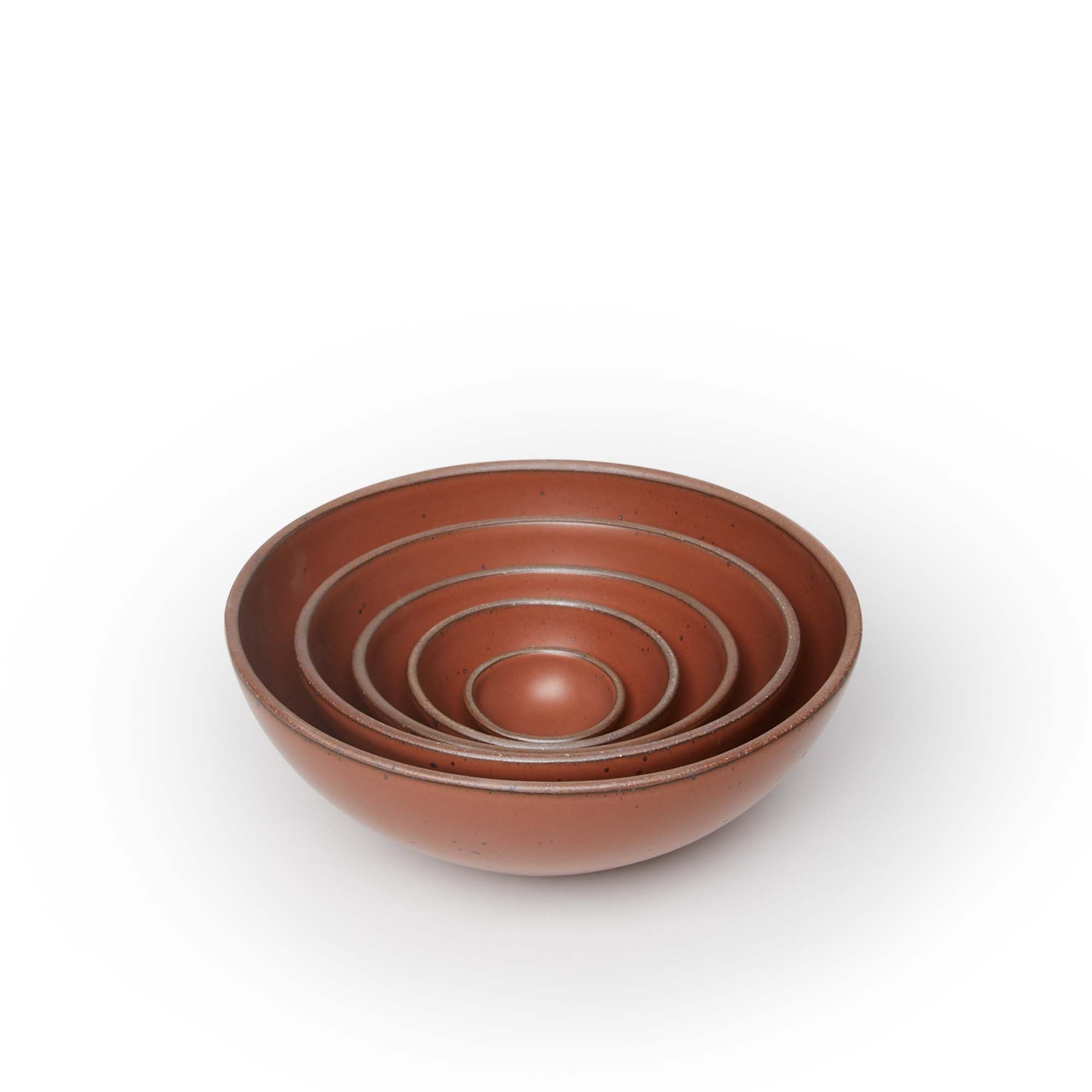 A bitty bowl, ice cream bowl, soup bowl, popcorn bowl, and mixing bowl paired together in a cool burnt terracotta color featuring iron speckles, nesting together