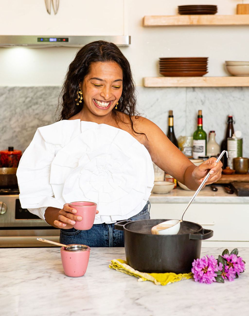 At home in Connie Matisse's kitchen, Sana Jeveri Kadri, founder of Diaspora Co., scoops freshly made house chai masal from a cast iron pot into an East Fork Chai Kulhad in Rococo.