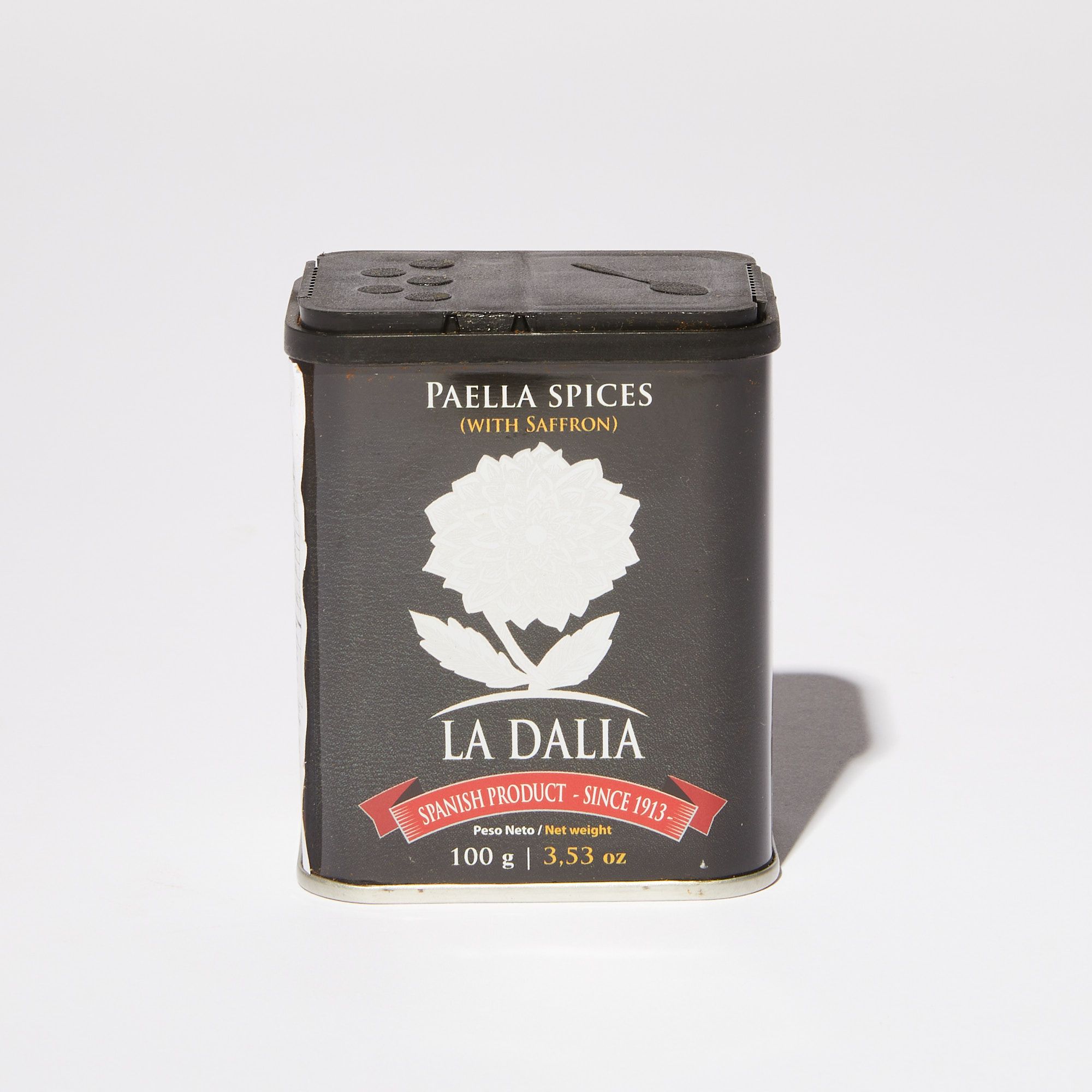 A black tin of paella spices with a white dahlia graphic