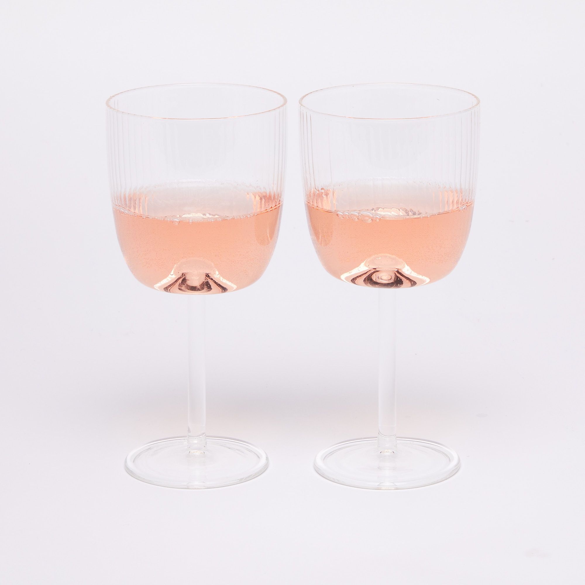 Two wine glasses with pink wine half full