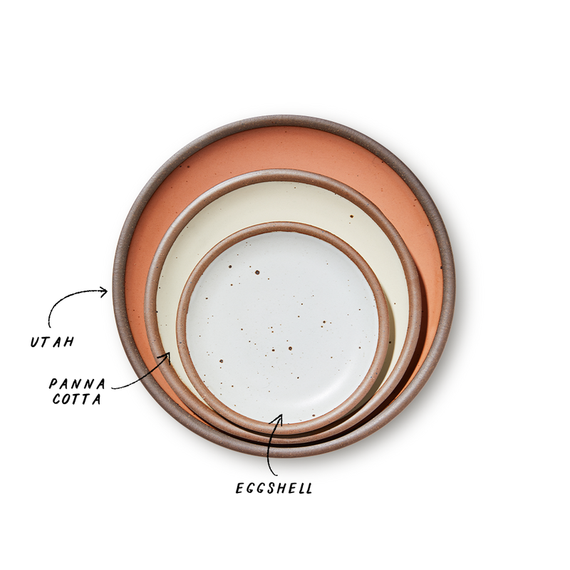 A stack of 3 plates in Dinner, Side, and Cake sizes in a warm peach, warm off-white, and white colors.