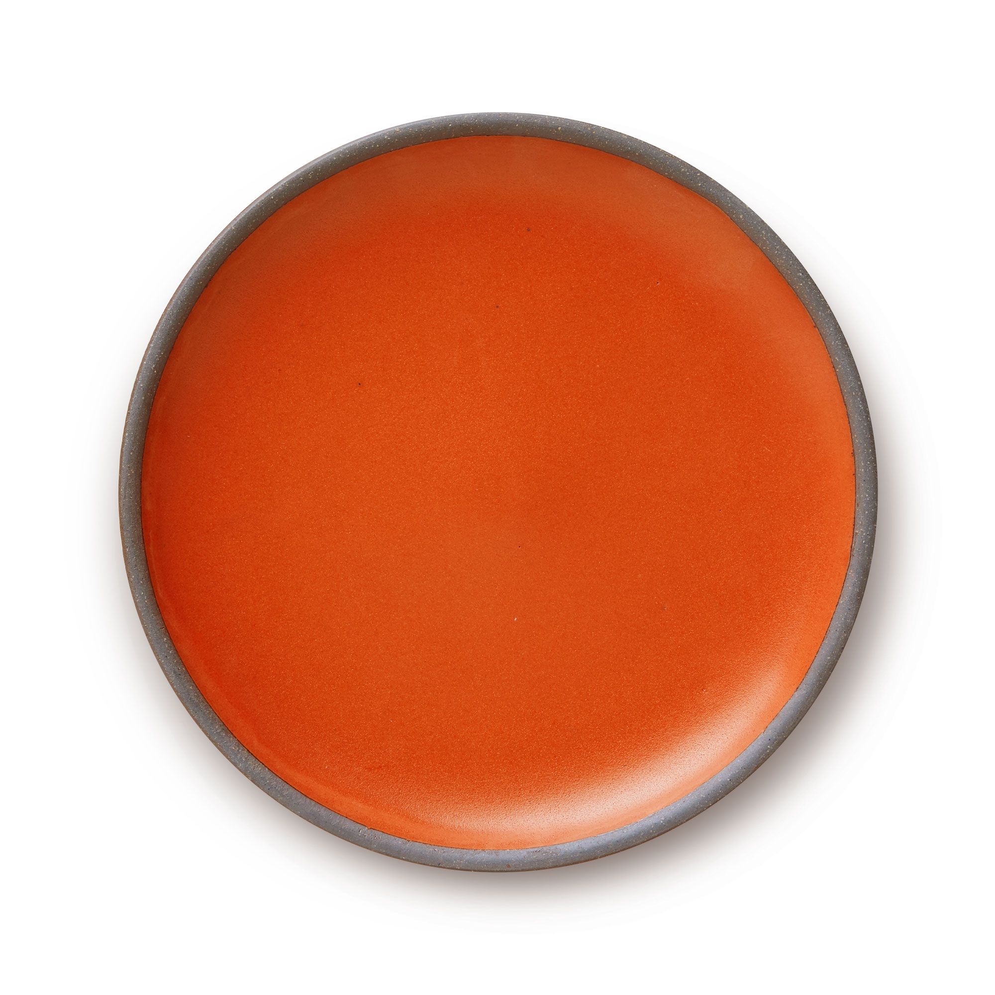 A large ceramic platter in a firey orange color featuring iron speckles and an unglazed rim.