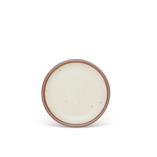 A dessert sized ceramic plate in a warm, tan-toned, off-white color featuring iron speckles and an unglazed rim.