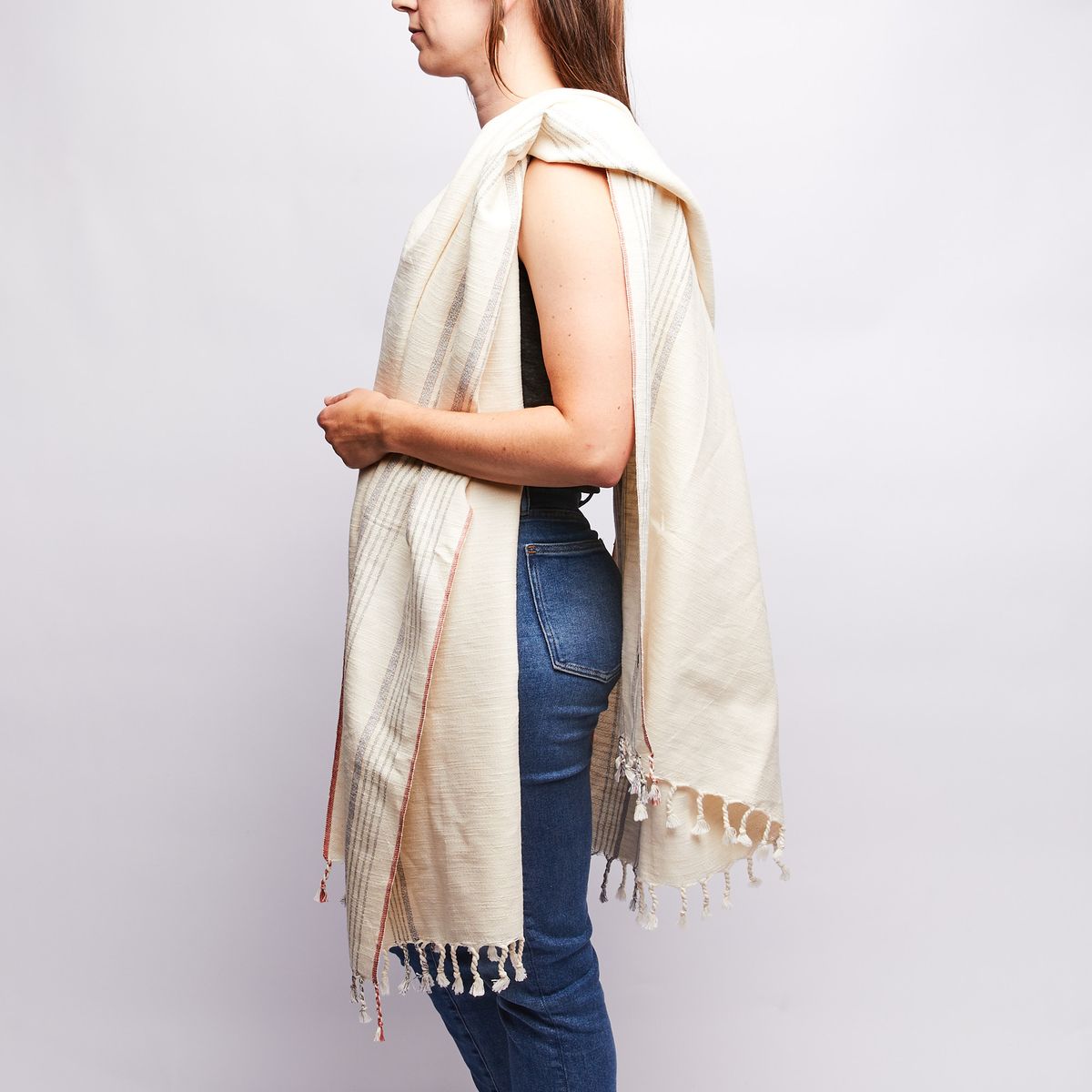 A cream-colored cotton Turkish towel rests over a person's left shoulder
