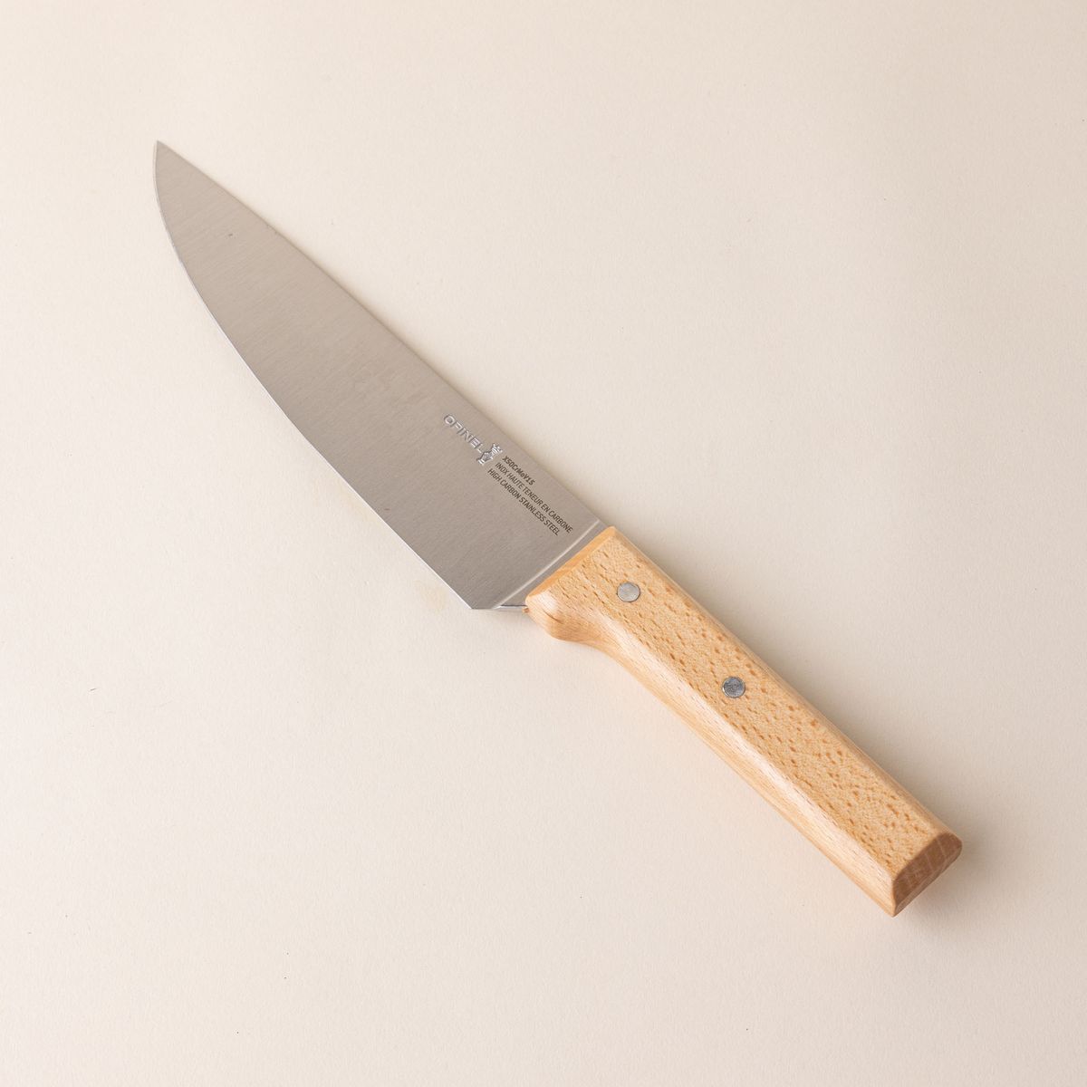 A chef's knife with a steel blade and a light wooden handle