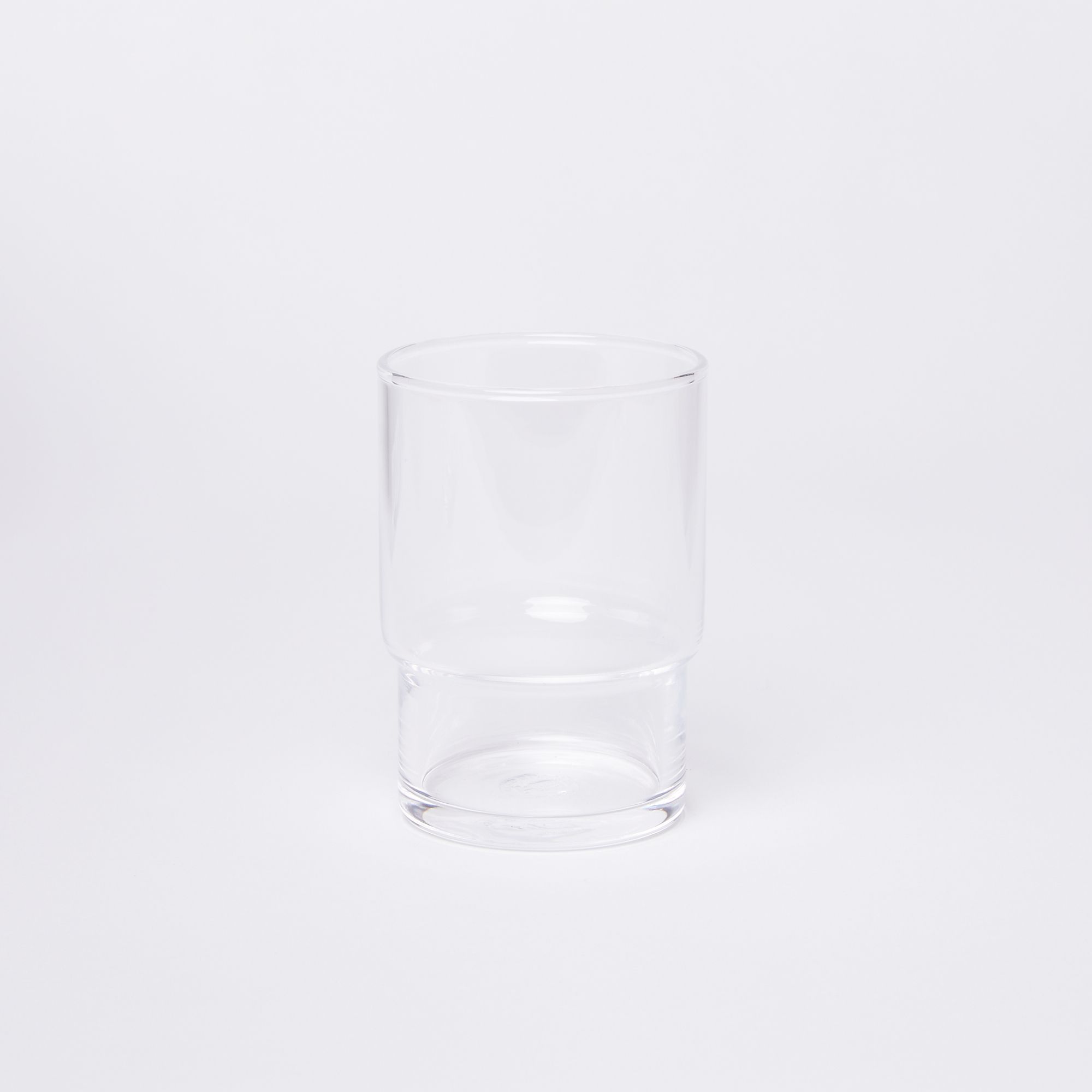 Clear cylindrical glass with a wider top half with a narrower bottom half