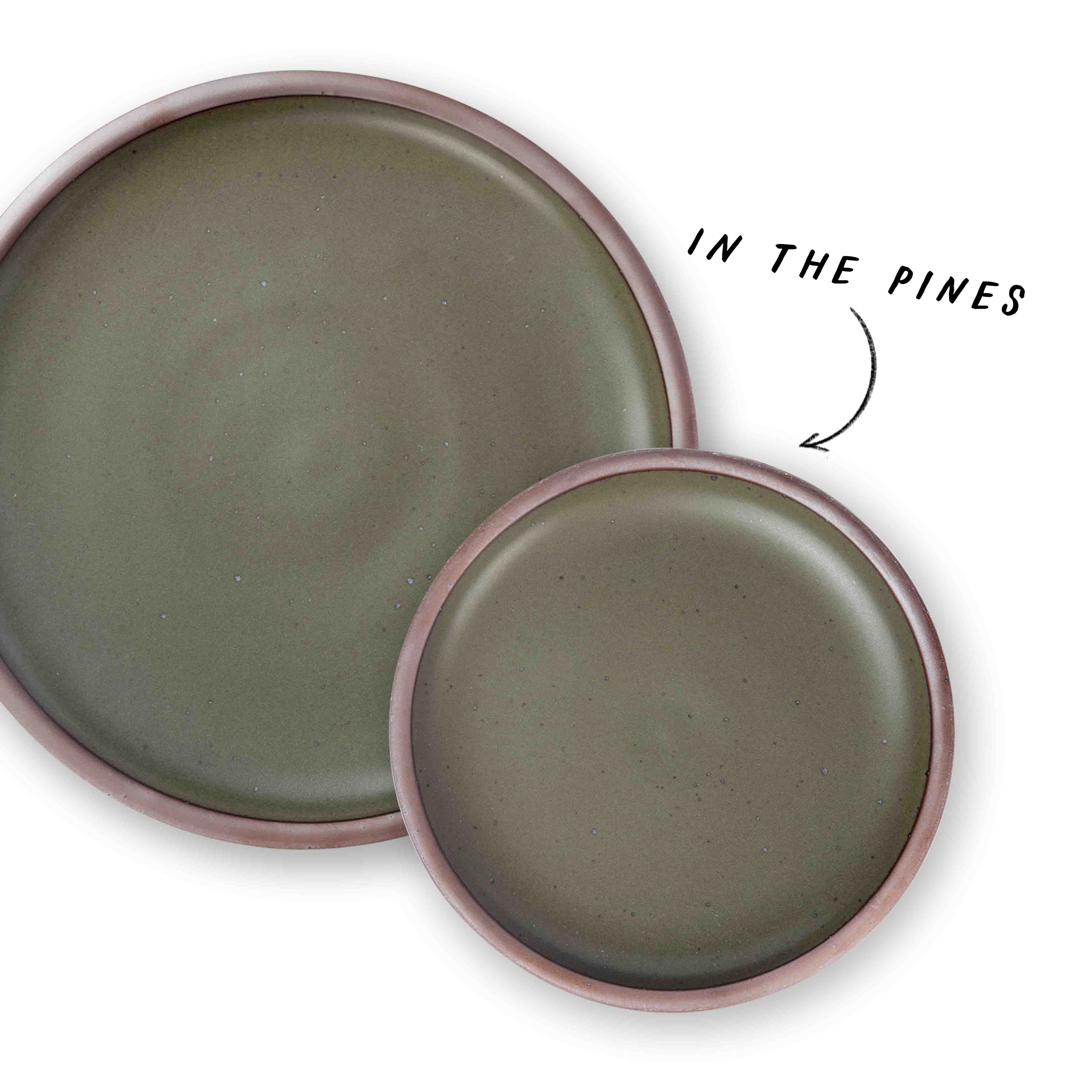 1 large and 1 small ceramic plate in a forest green with an arrow pointing to both that reads 'In the Pines'