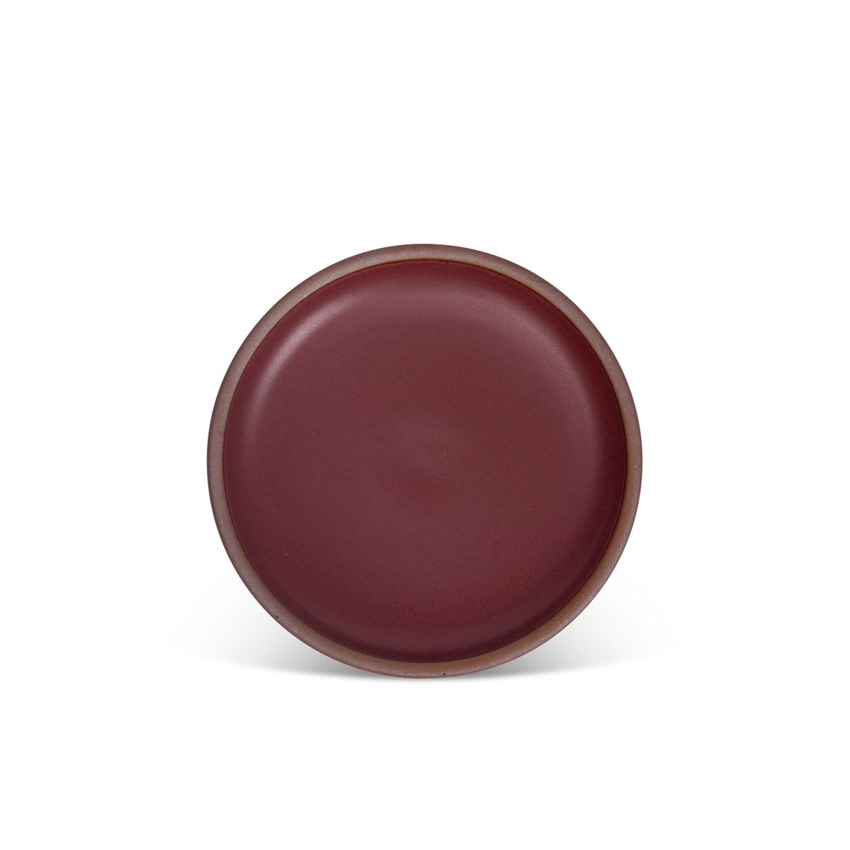 A medium sized ceramic plate in a plum color featuring iron speckles and an unglazed rim.