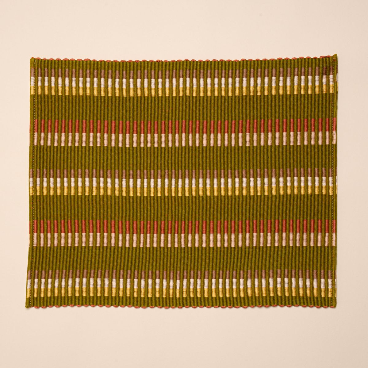 Rectangle placemat with offset stripe design that is hand woven in olive, tan, orange, and yellow colors