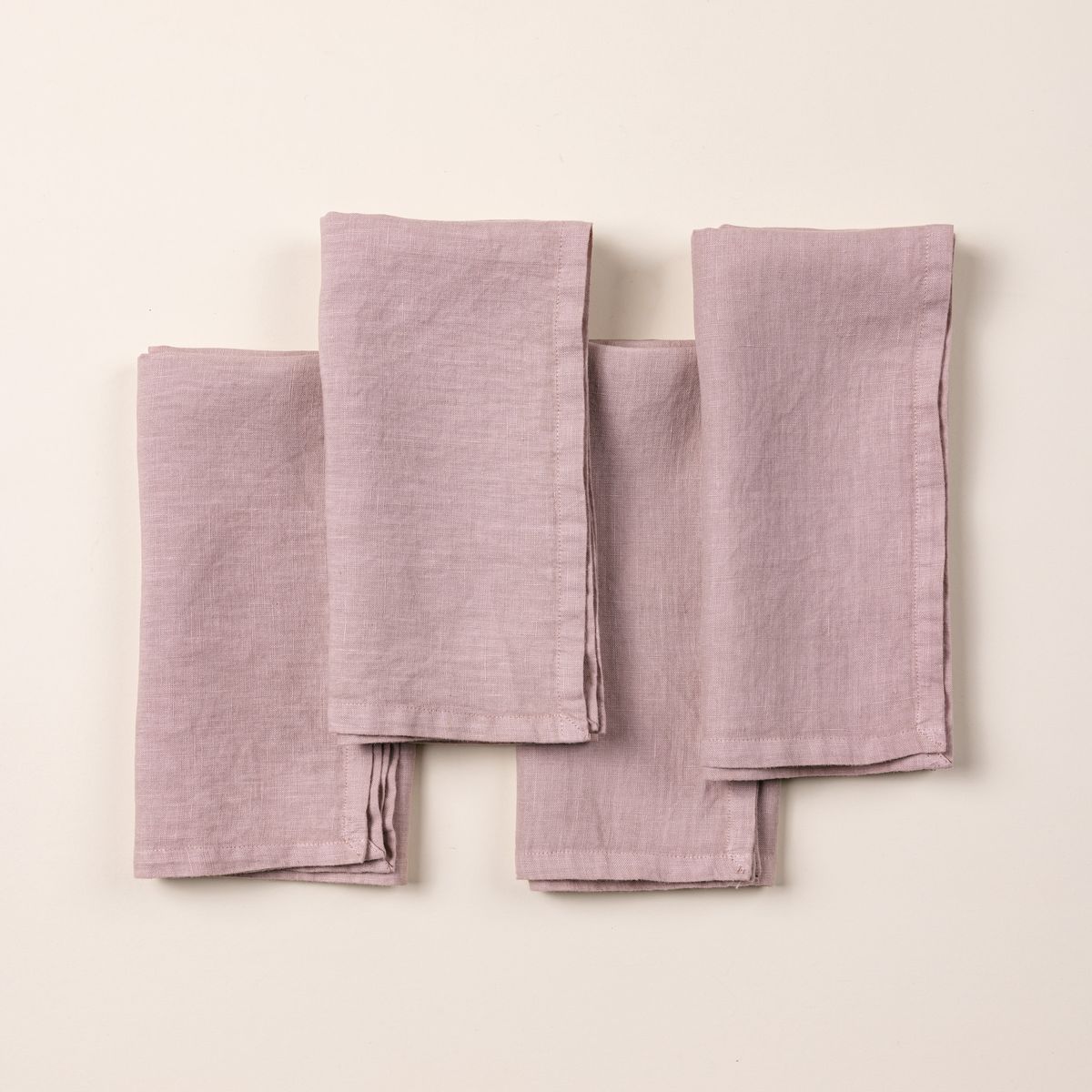 4 folded linen napkins in a soft pink color