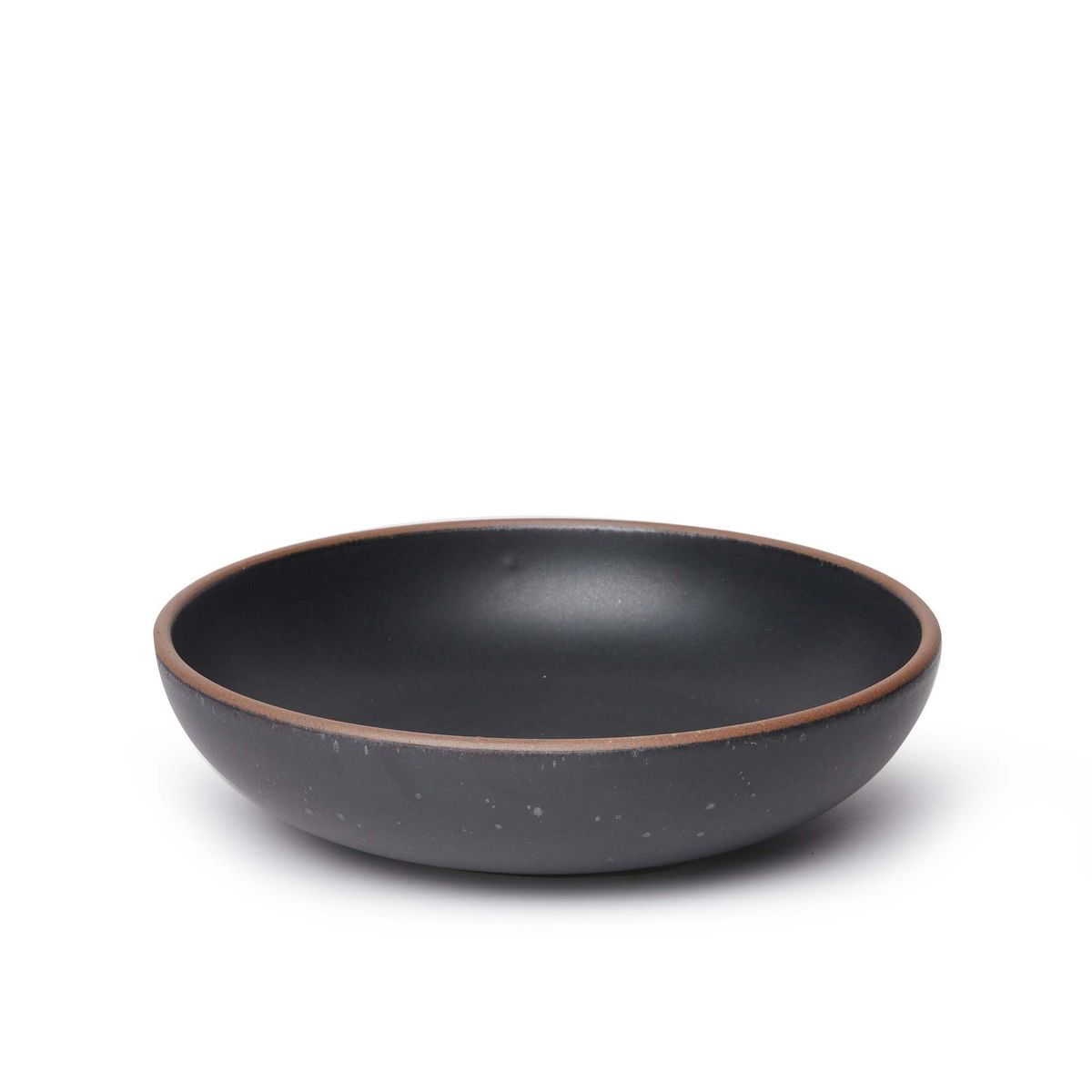 A large shallow serving ceramic bowl in a graphite black color featuring iron speckles and an unglazed rim