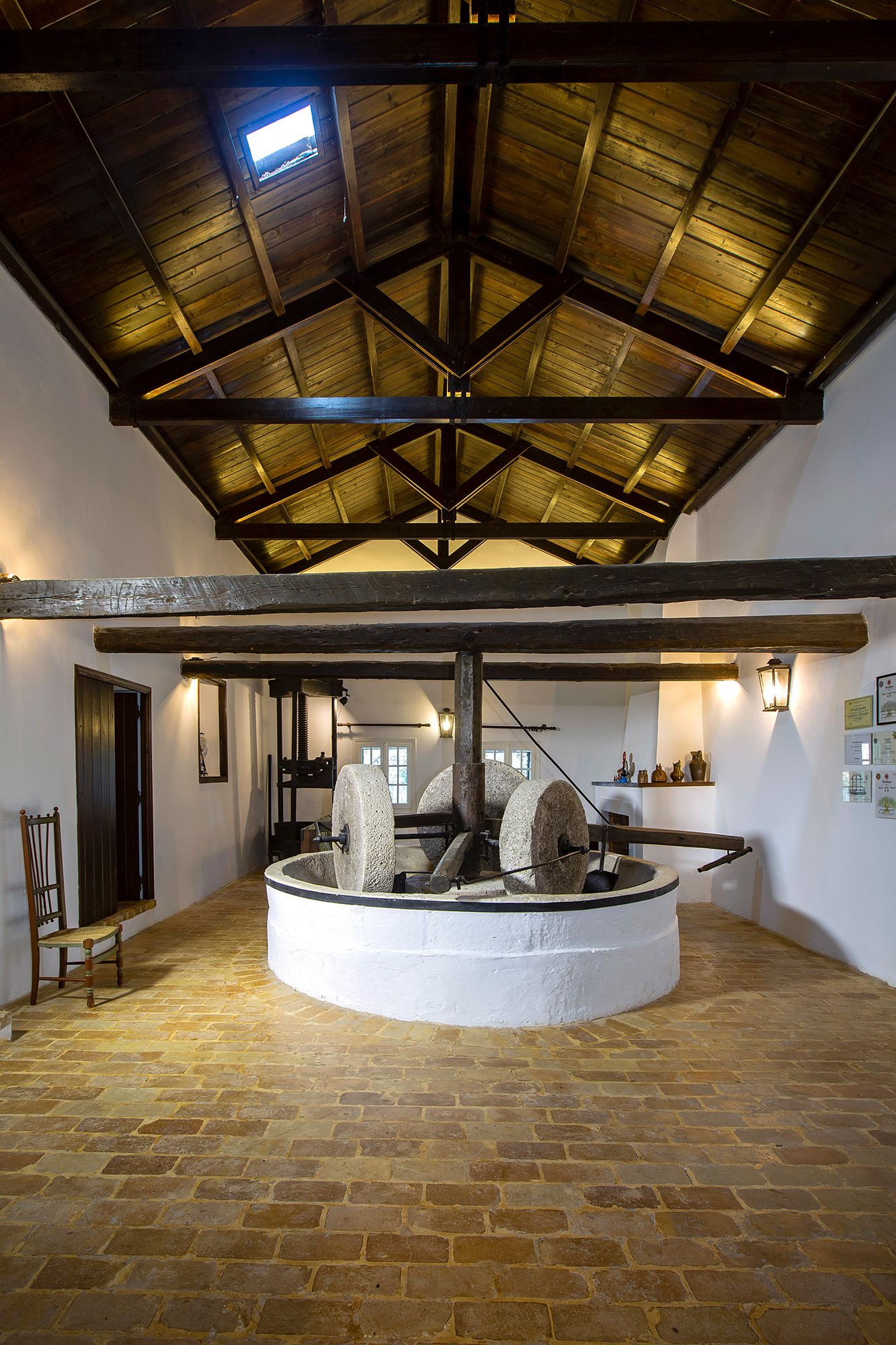 A look inside at a large machine for olive oil inside a farmhouse.