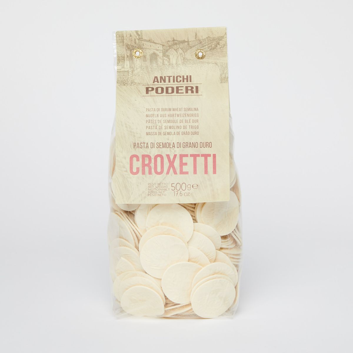 Clear plastic bag of disc-shaped pasta with a tan label that reads "Croxetti" in pink