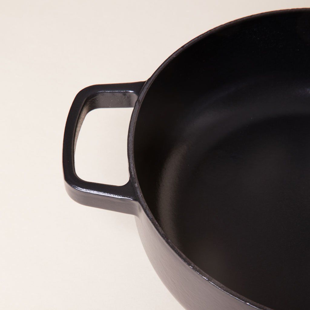 Handle, edge and interior of black cast iron pot