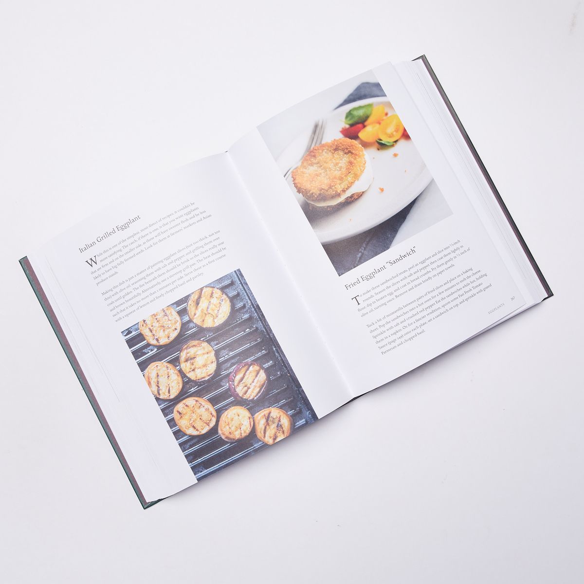 Open cookbook with a photo of grilled eggplant on the left page and fried eggplant on the right
