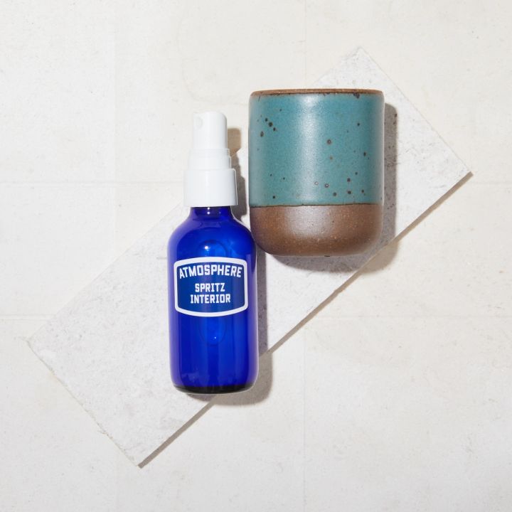 Bright blue bottle with a white spray top lying next to a turquoise toddler cup
