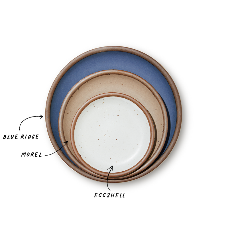 A stack of 3 plates in Dinner, Side, and Cake sizes in a navy, warm light brown, and white colors.