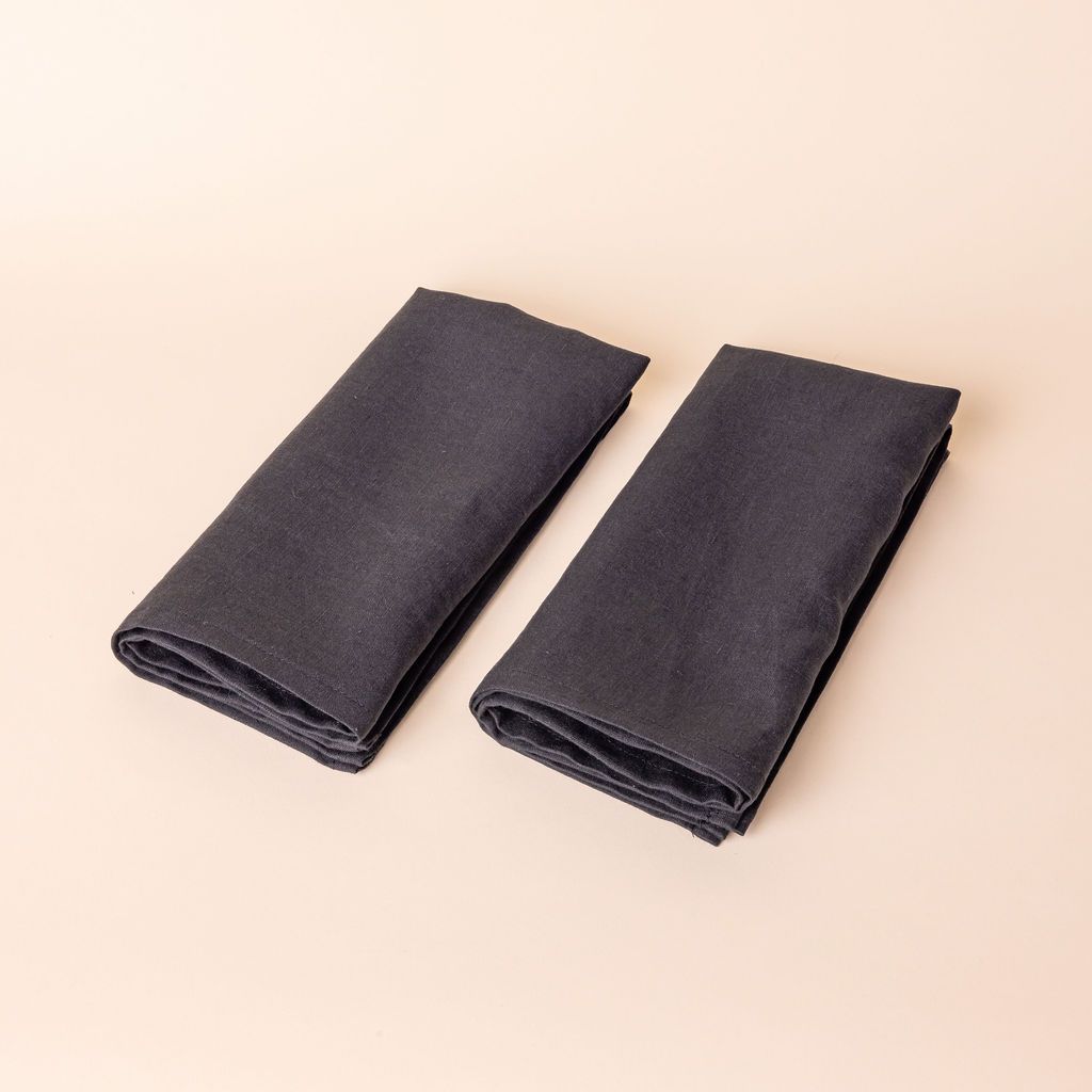 Two charcoal linen napkins folded into rectangles side by side