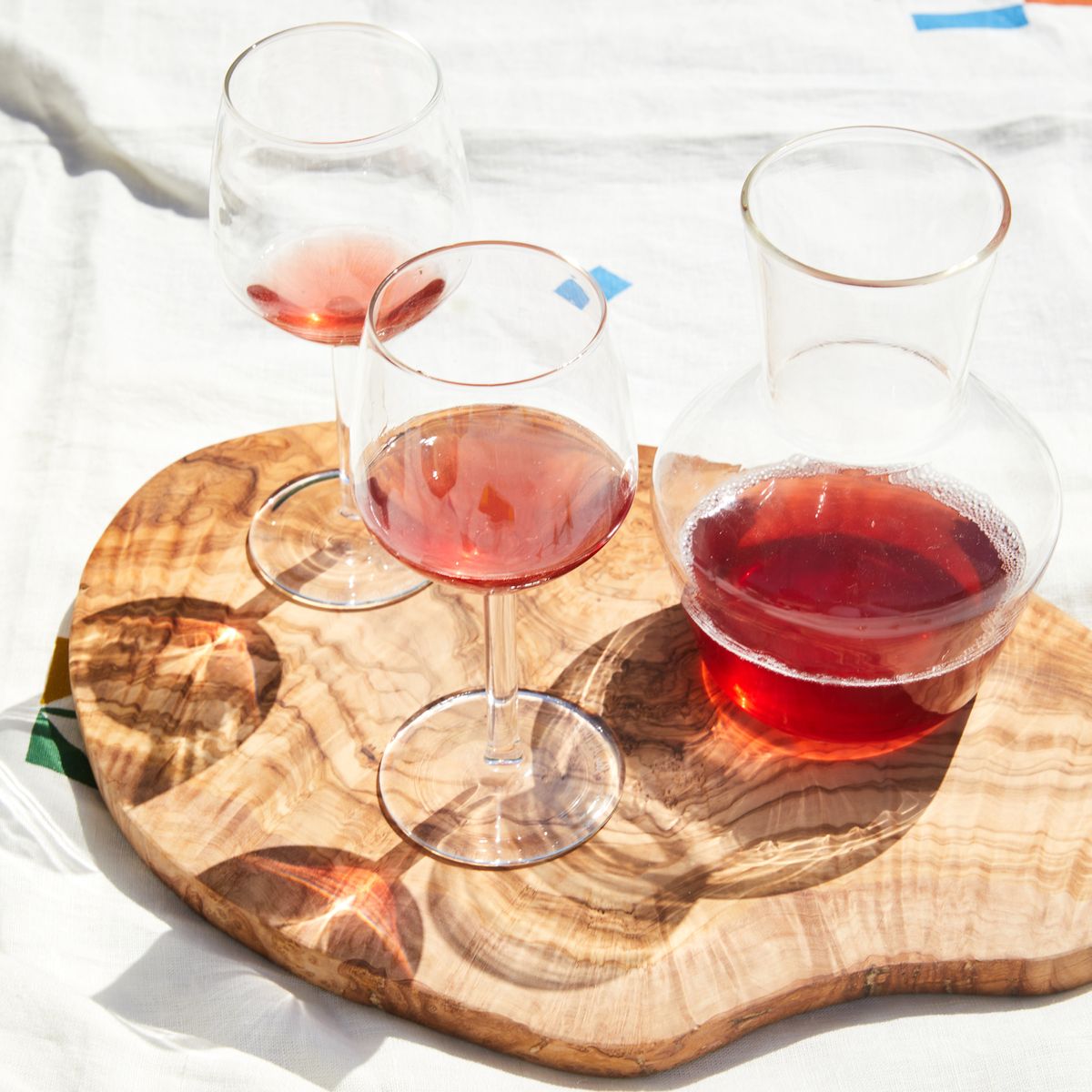 set of wine glasses on a cutting board with carafe