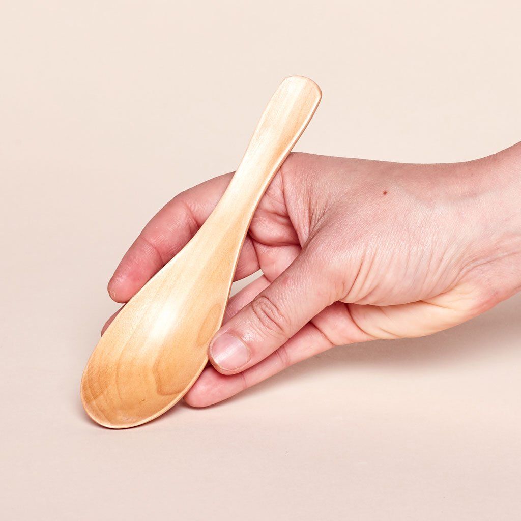 Hand holding a wooden soup spoon that measures 6 inches long