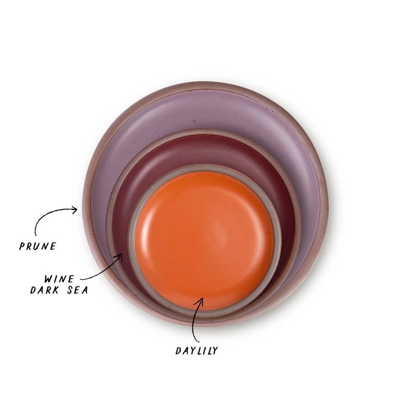 A stack of 3 plates in Dinner, Side, and Cake sizes in a soft mauve purple, plum, and bold orange colors.