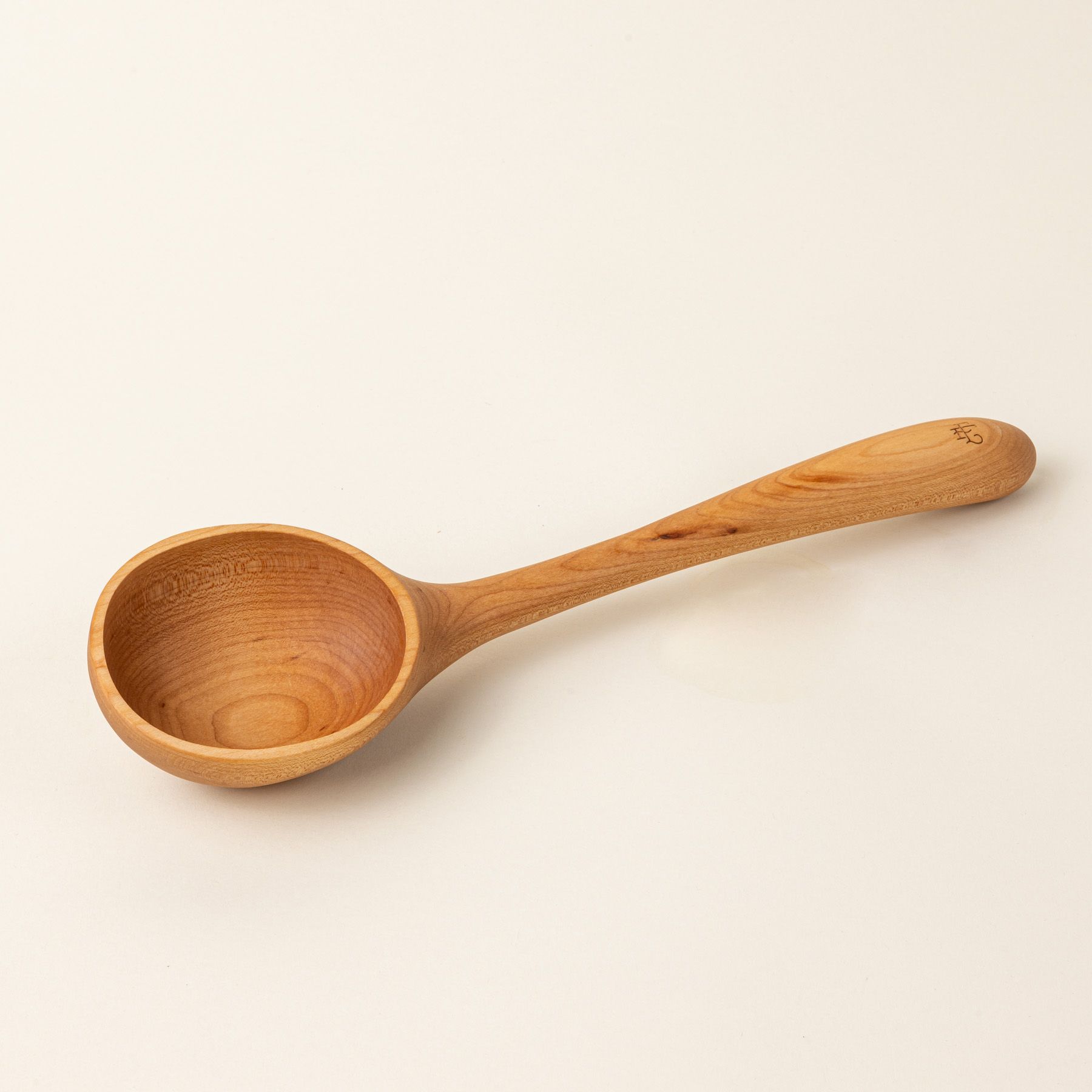A wooden ladle with a large scoop