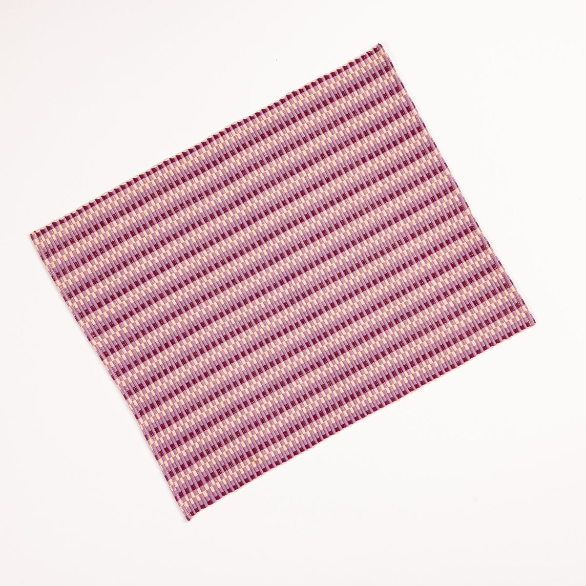 A woven placemat with thin horizontal striped tonal plum and blush colors