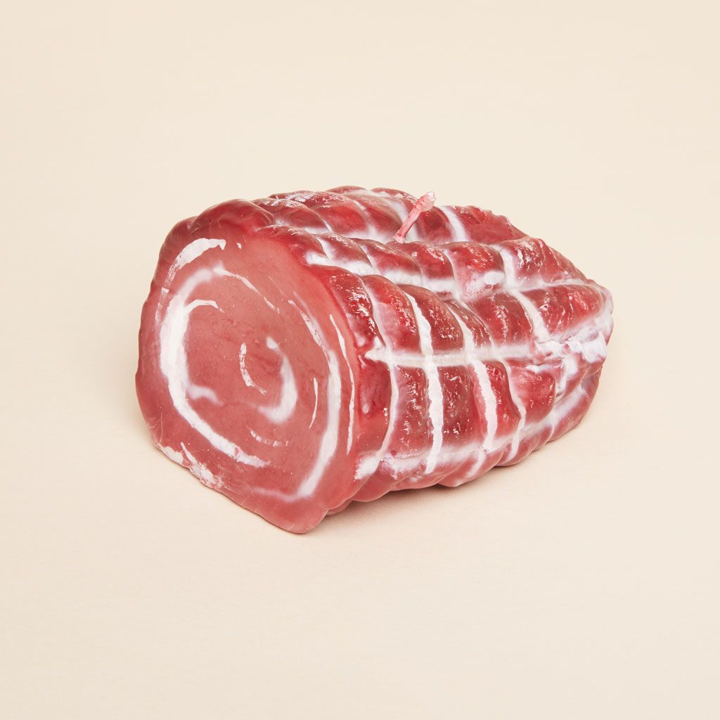 A red, pink and white candle that mimics an Italian meat known as capicola
