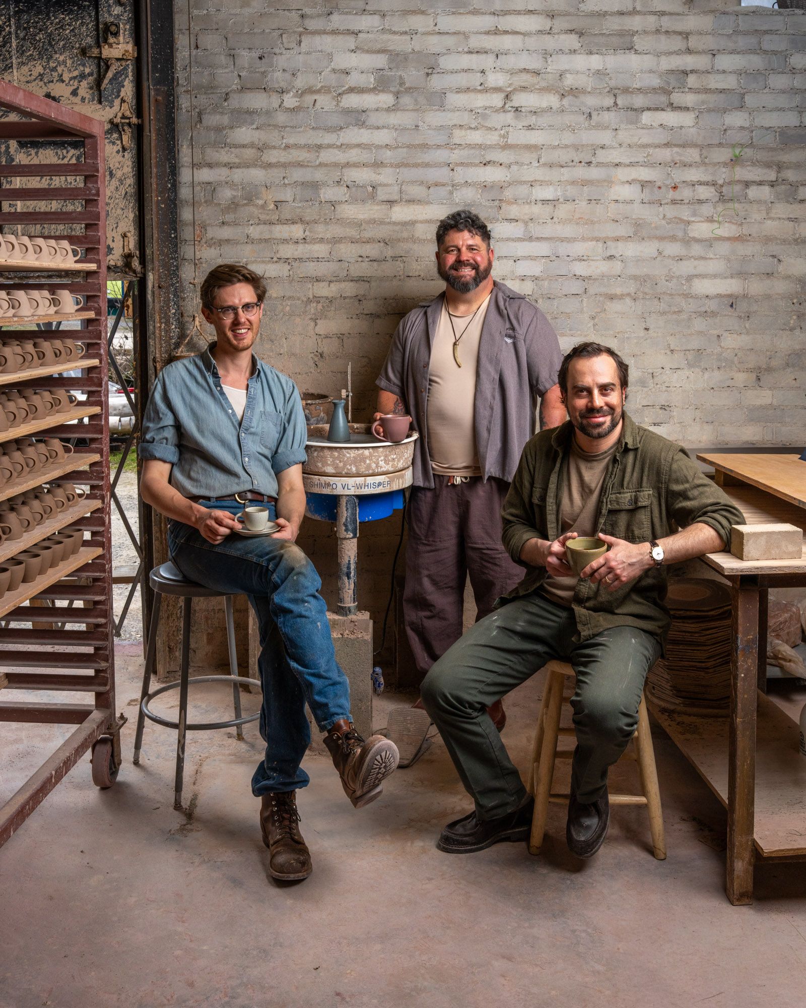 Alex, Mike and John smiling and holding workshop mugs and espresso cups in East Fork Workshop.
