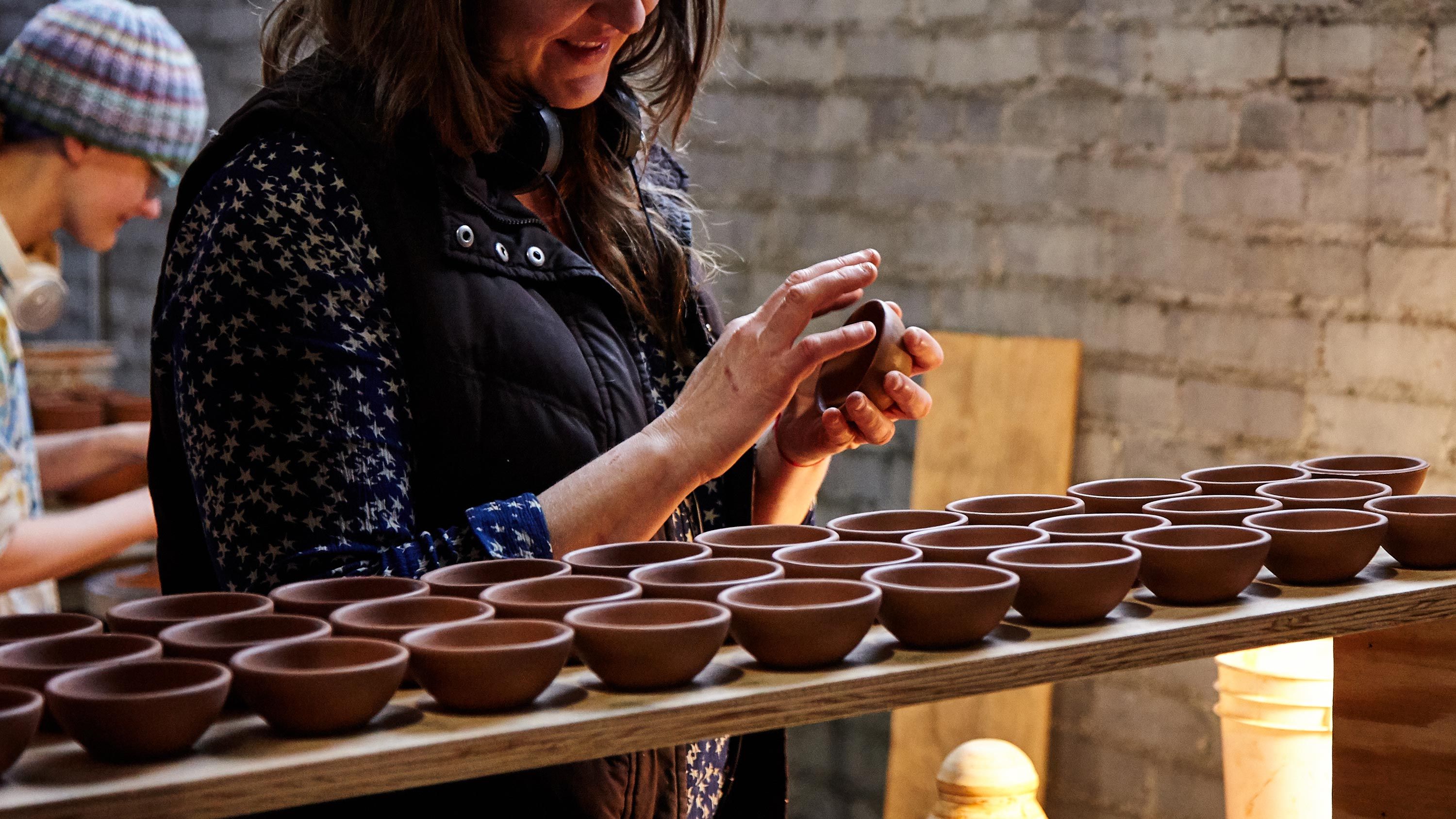 person cleaning rims of bitty bowls by hand