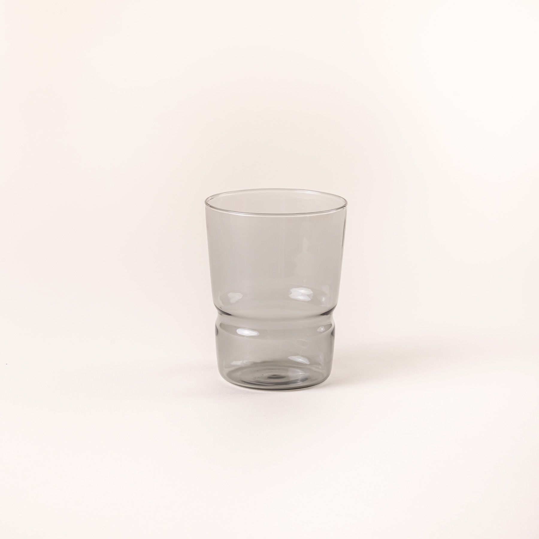 Tumbler glass that widens at the top in a grey color