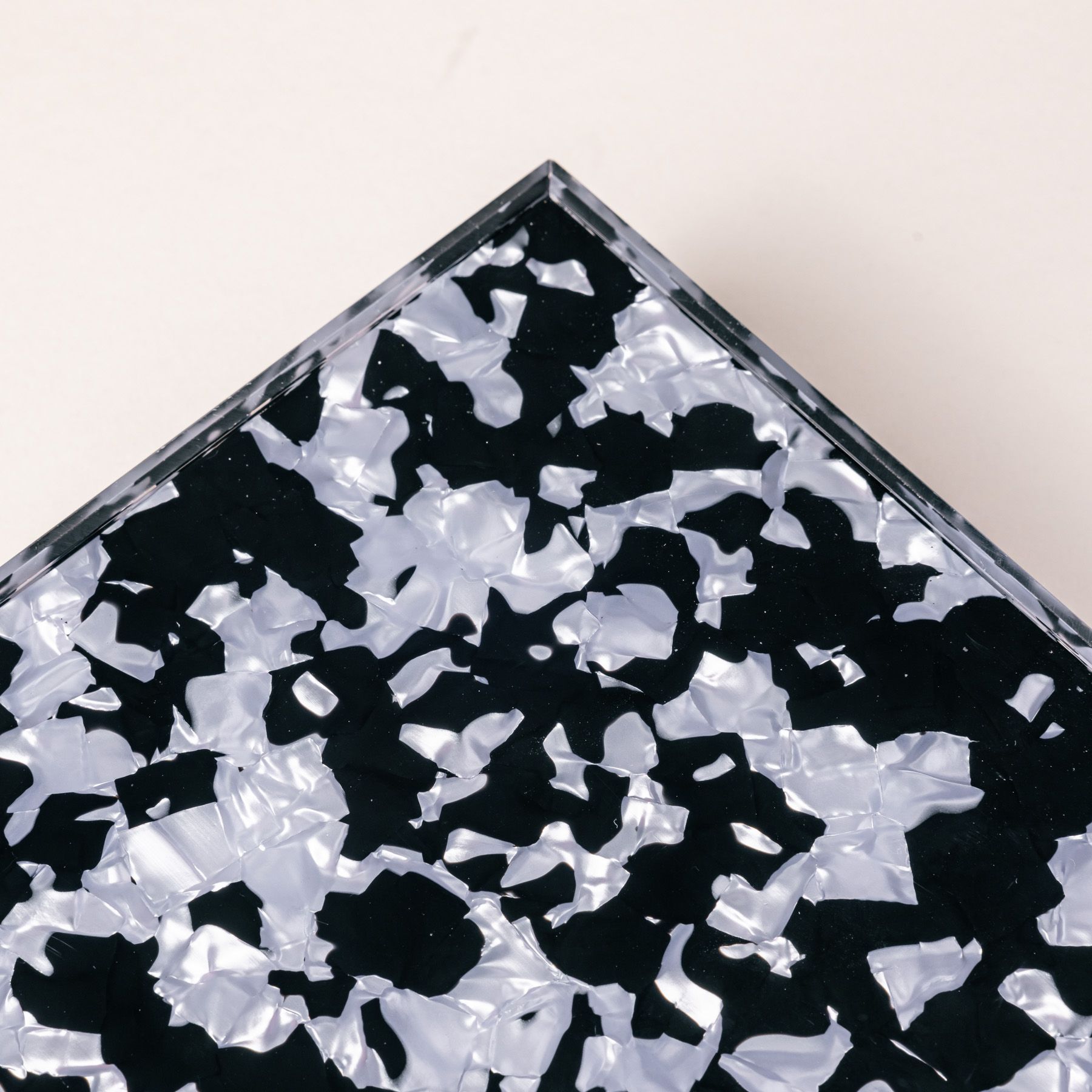 A close up of a rectangular acrylic tray with a black and light blue granite-like design