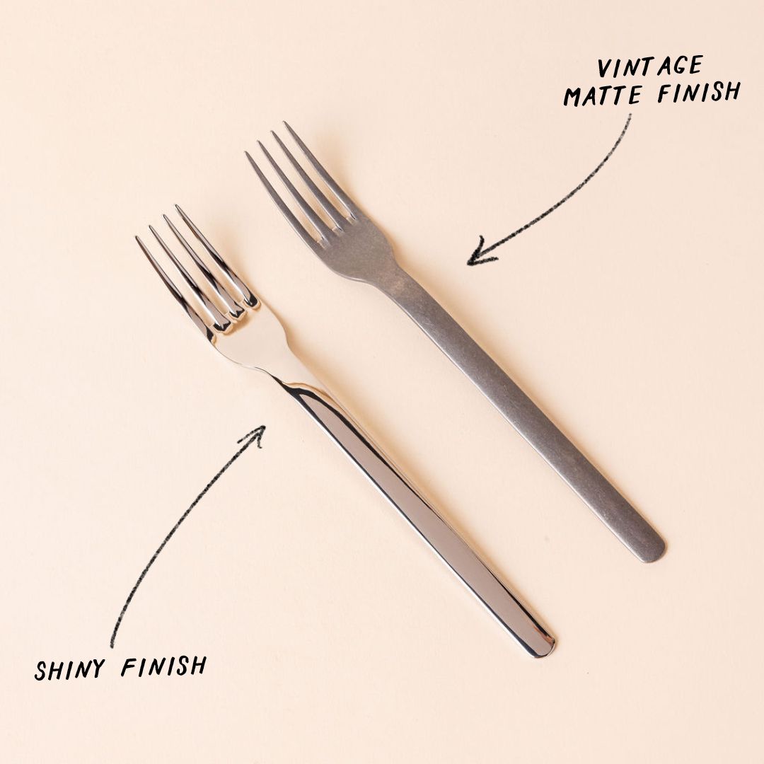Two forks arranged side by side, with a drawn graphic with an arrow pointing to each fork. The right fork has a vintage matte finish, the left fork has a shiny finish.
