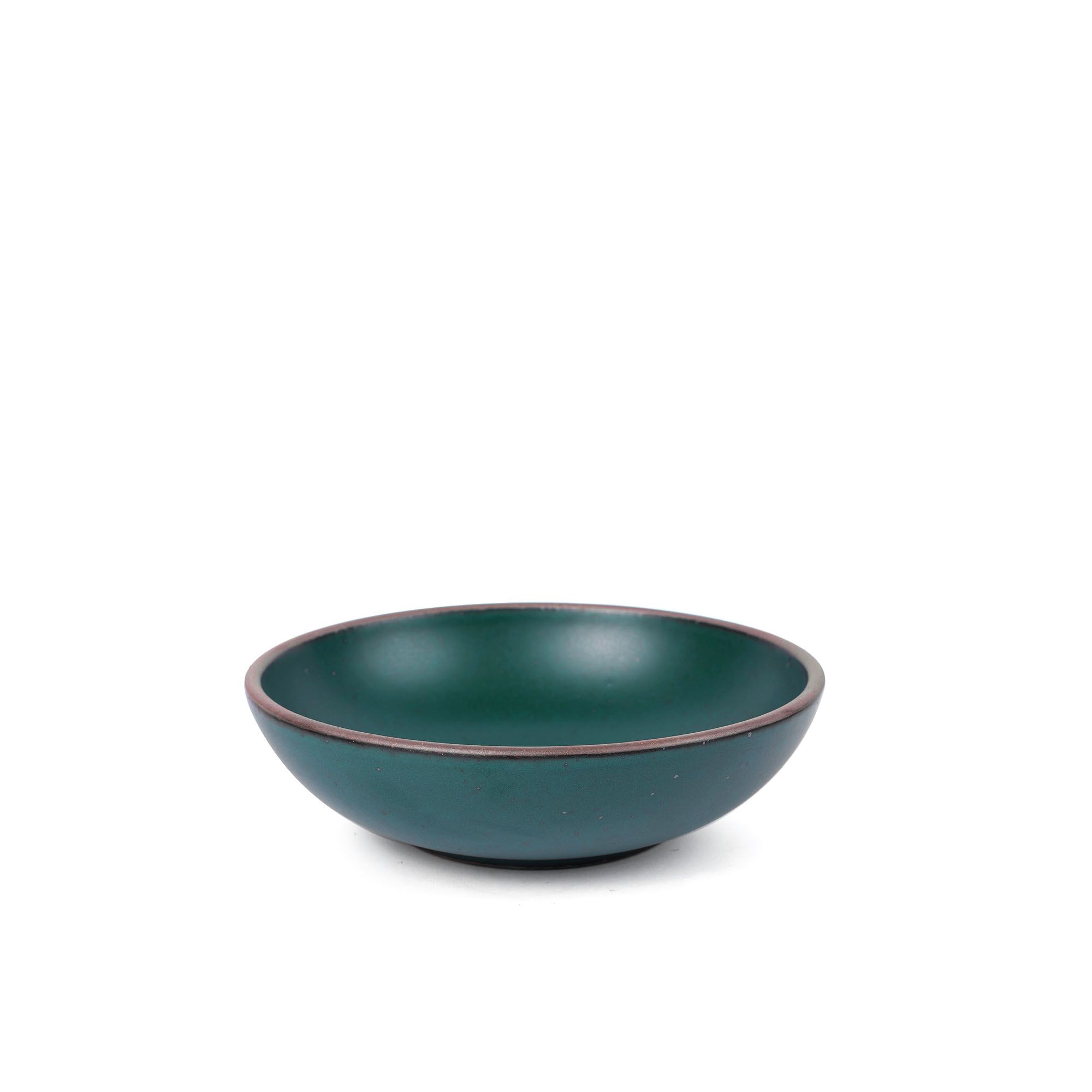 A dinner-sized shallow ceramic bowl in a deep dark teal color featuring iron speckles and an unglazed rim