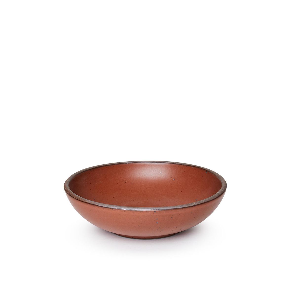 A dinner-sized shallow ceramic bowl in a cool burnt terracotta color featuring iron speckles and an unglazed rim