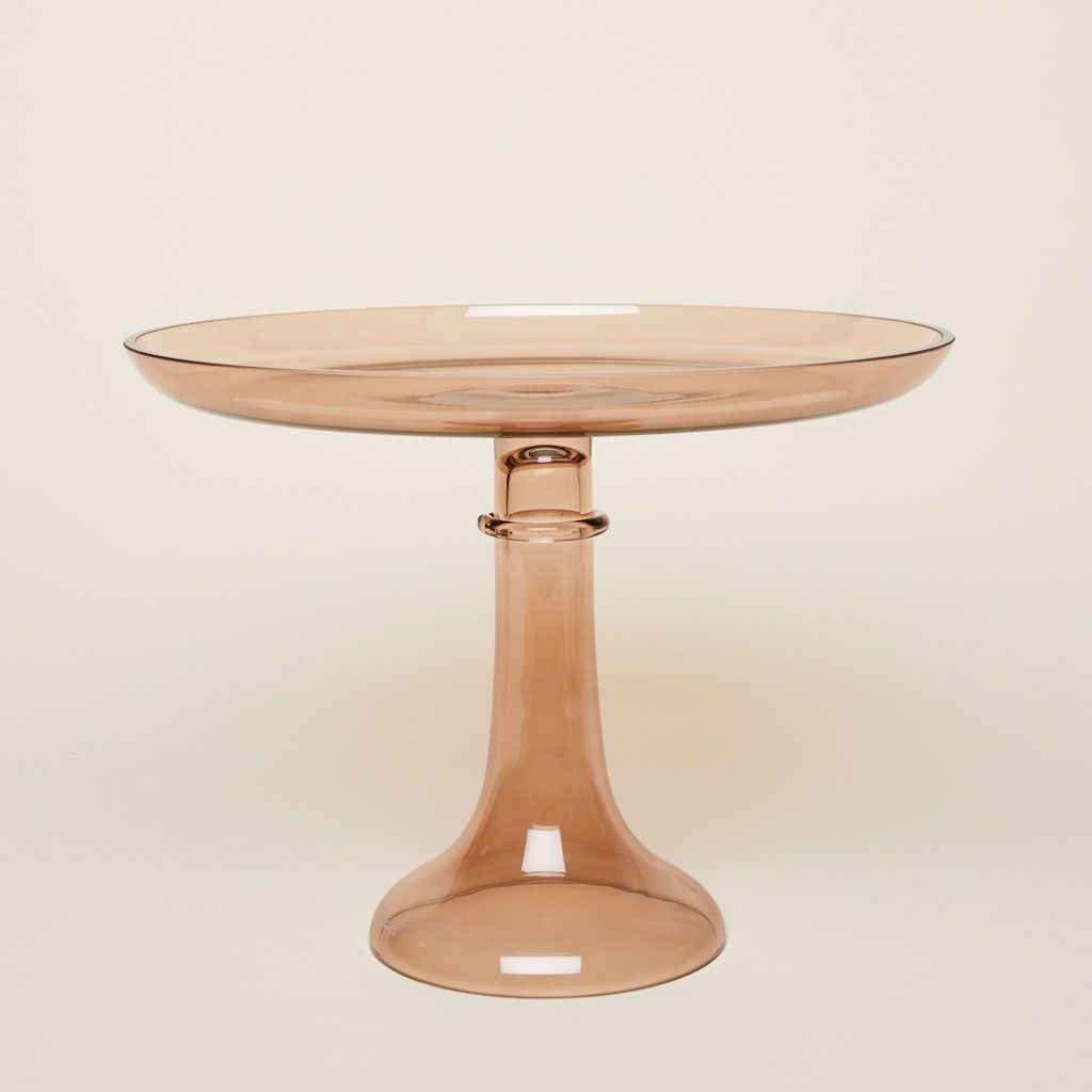 A glass cake stand in amber