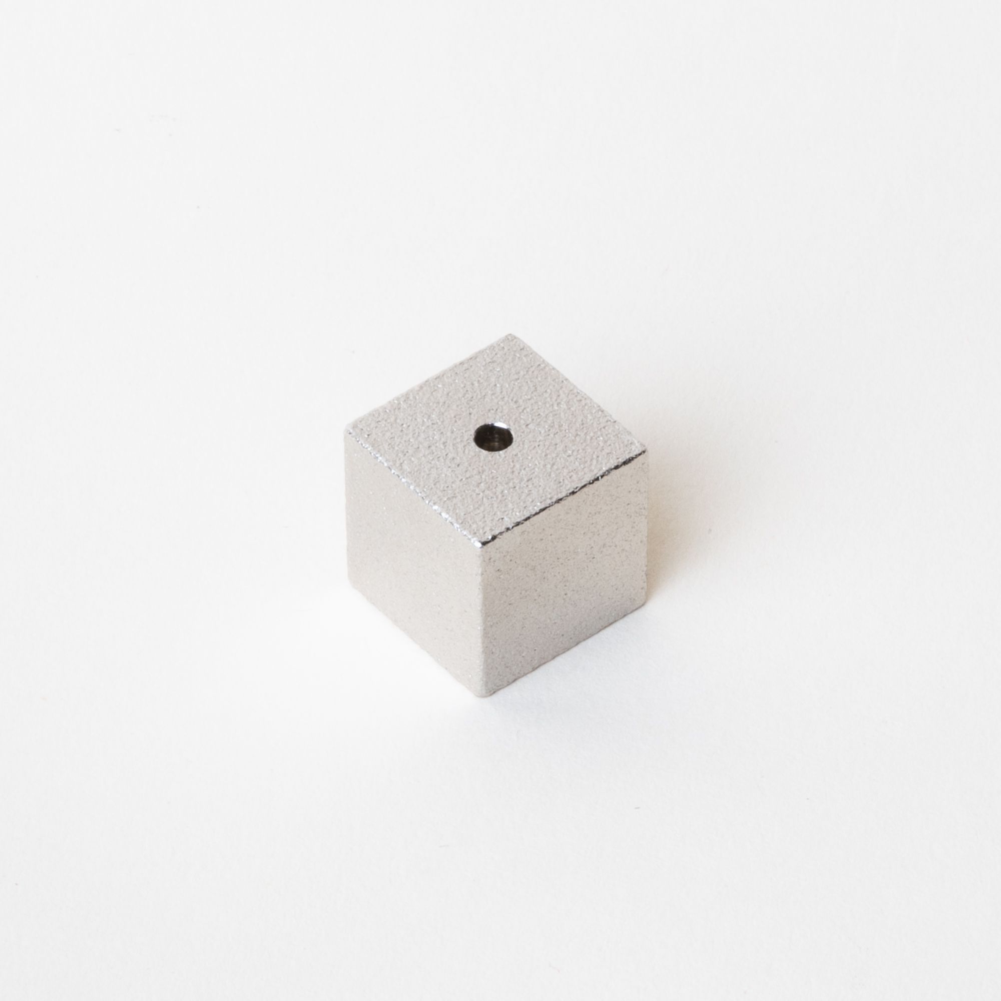 Minimal cube made of pewter with a small hole on the top for incense