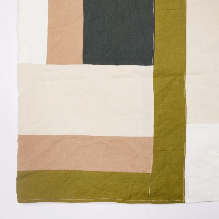 Corner of tablecloth with tan, cream, mossy green, and charcoal rectangular shapes