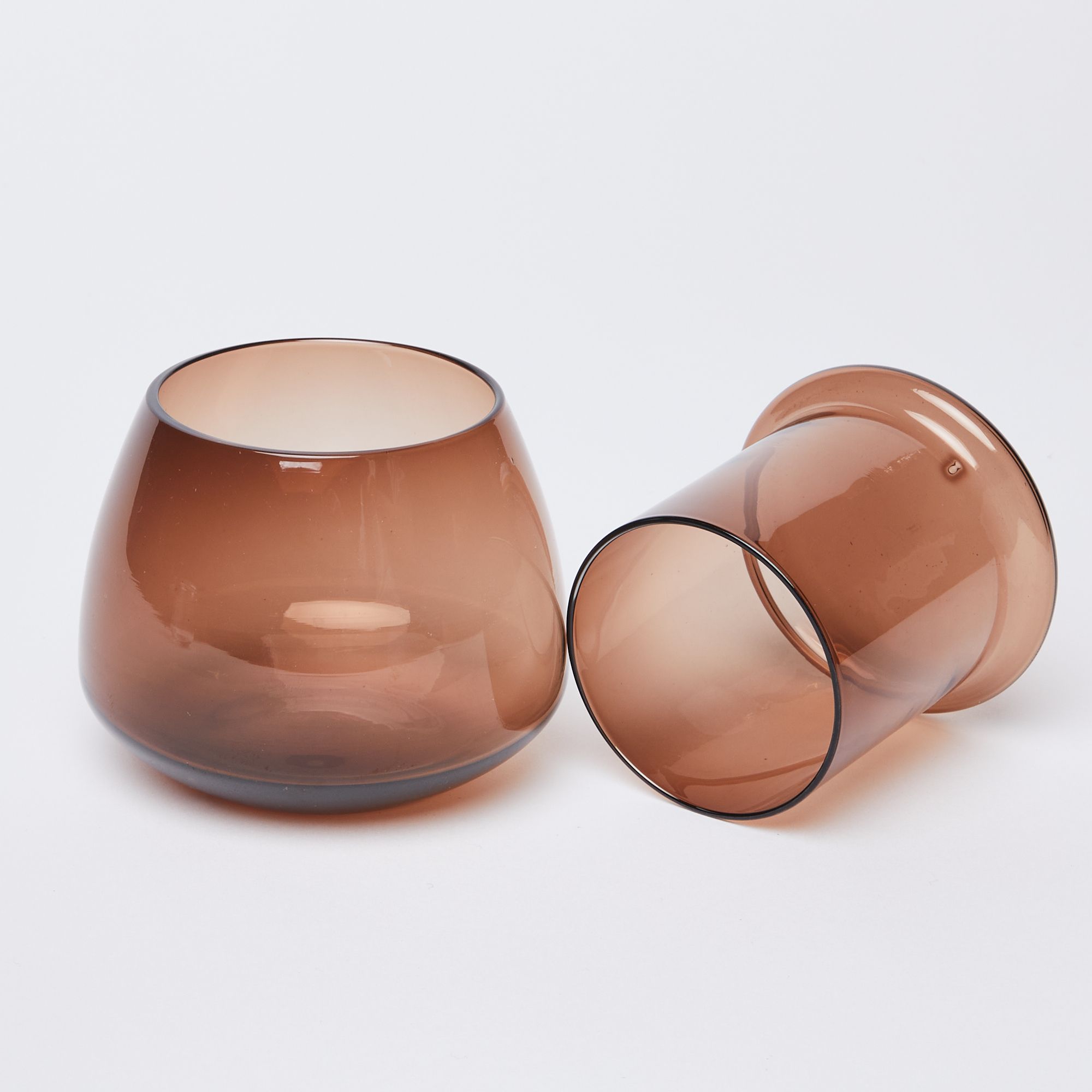 The top of the butter keeper resting to the right of the rounded base, both brown glass