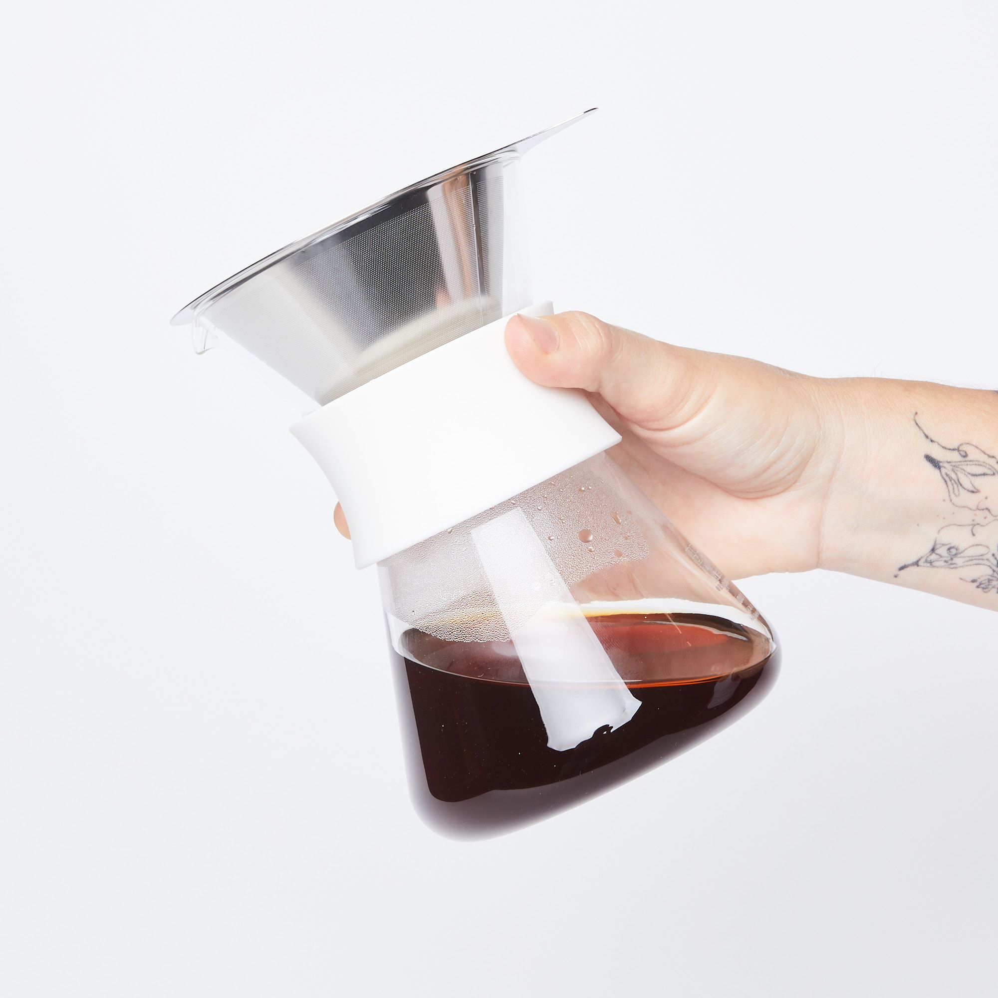 hand holding glass coffee maker with coffee in it