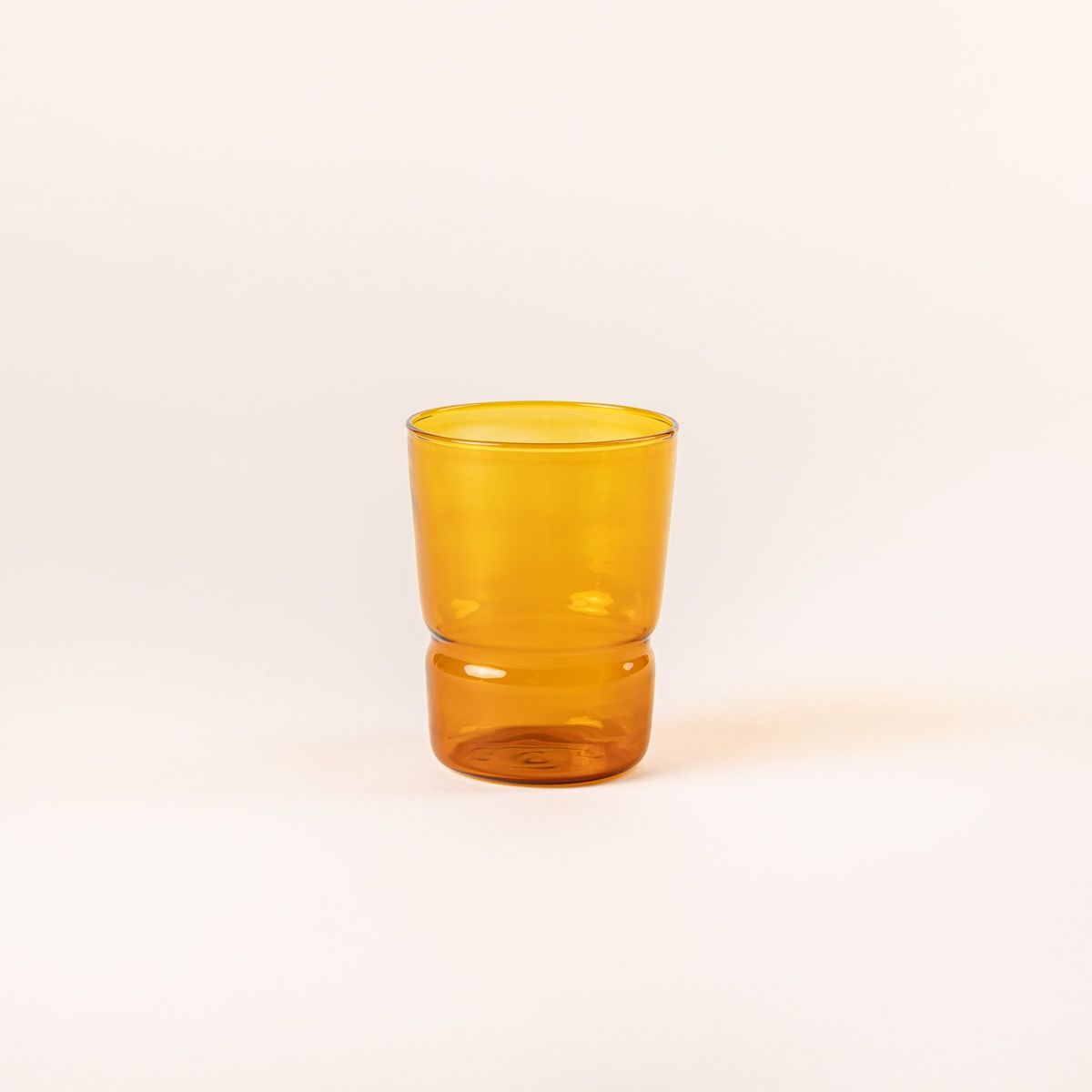 Tumbler glass that widens at the top in an amber color