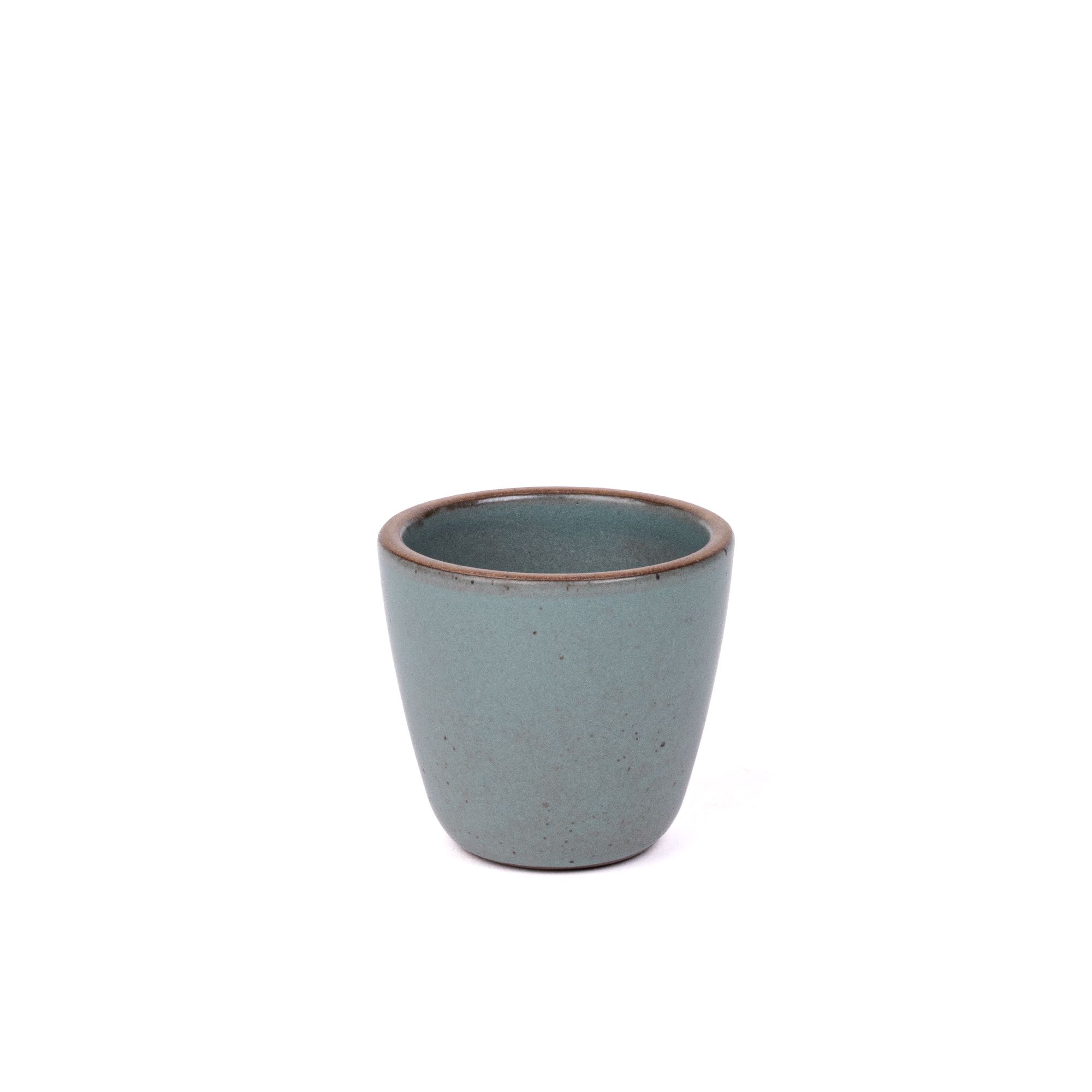 A short cup that tapers out to get wider at the top in a blue-grey color featuring iron speckles