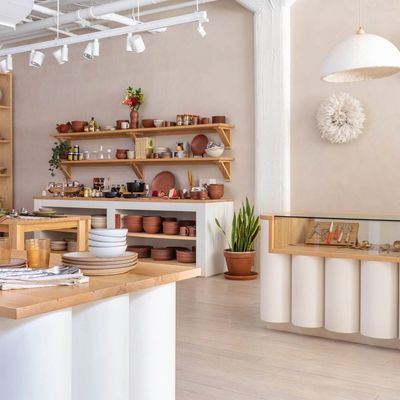 Inside East Fork Atlanta, filled with artful tables and a cash wrap, wall shelves with pottery and a beautiful checkerboard shelf with pottery and other objects