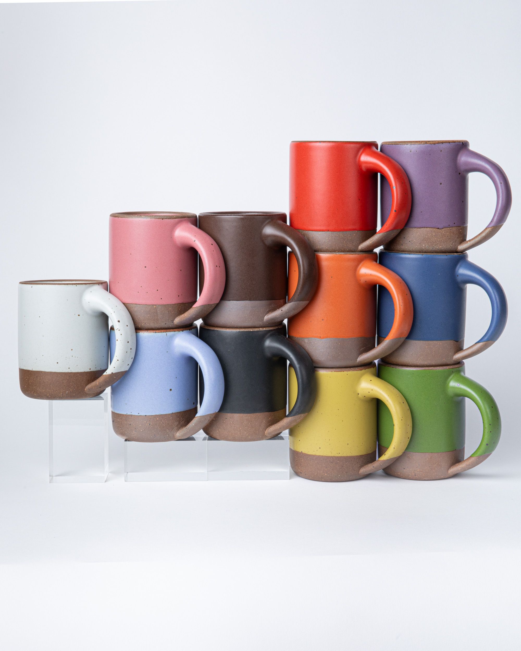 Colorful ceramic mugs are formed in a triangle to symbolize the Progress Pride flag.