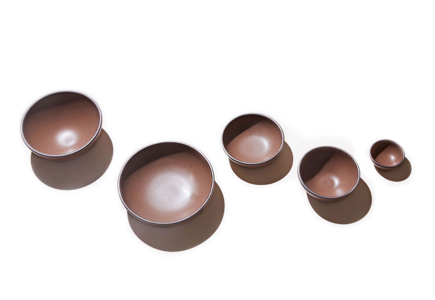 Five bowls in descending sizes all in a warm brown color against a white background.