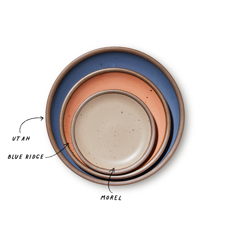 A stack of 3 plates in Dinner, Side, and Cake sizes in a navy, peach, and pale warm brown colors.