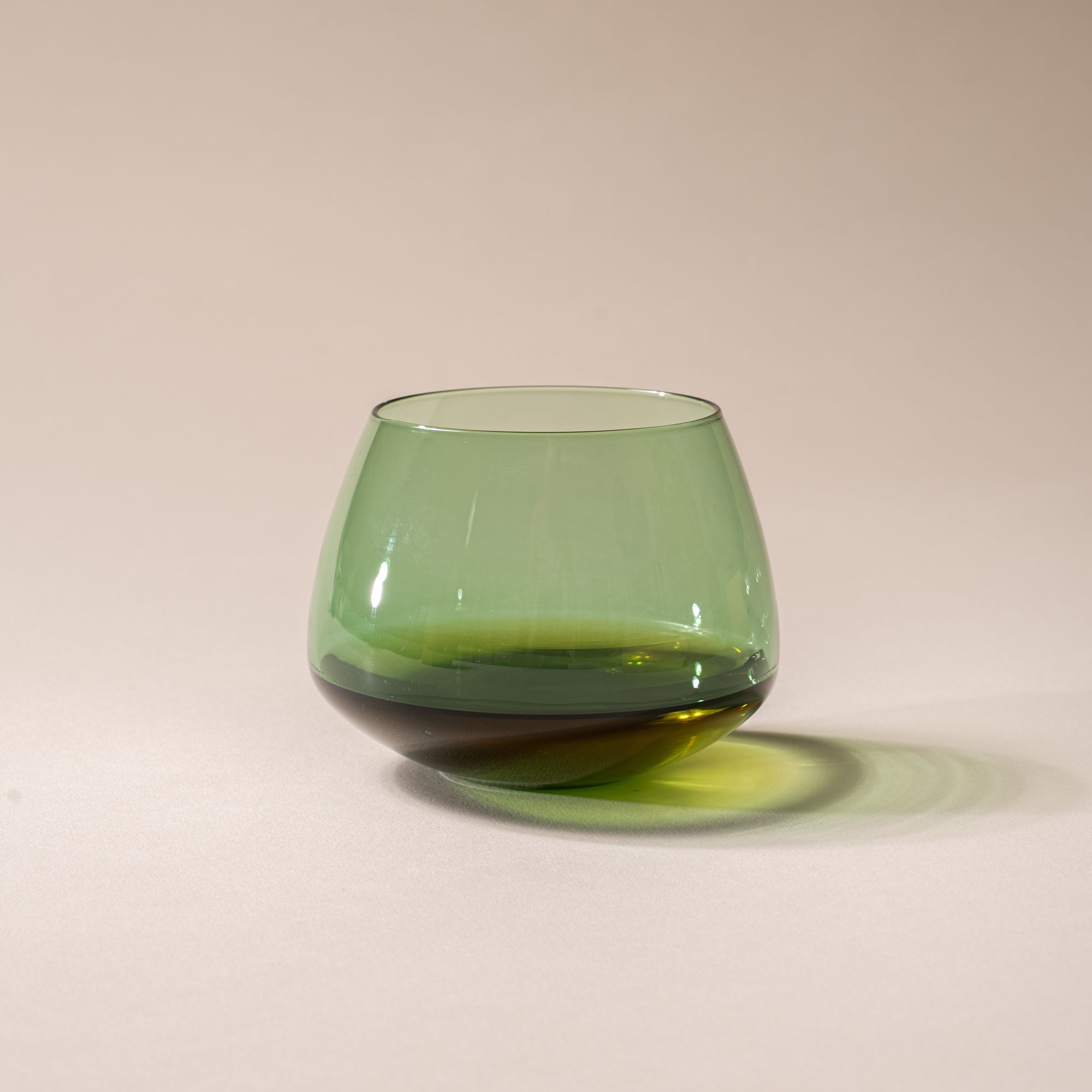 Whiskey in a green glass whiskey snifter with a rounded base