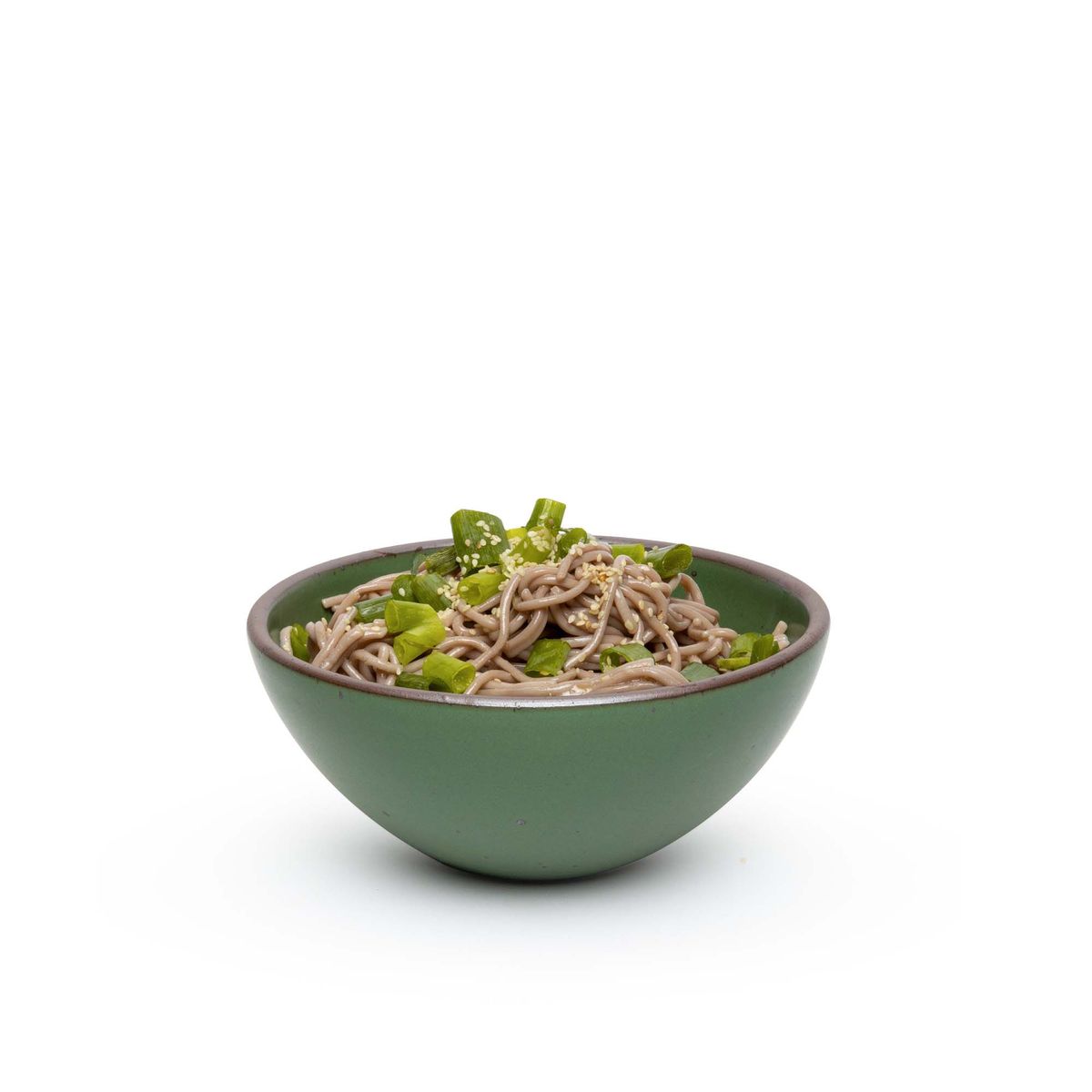 A medium rounded ceramic bowl in a deep, verdant green color featuring iron speckles and an unglazed rim, filled with noodles