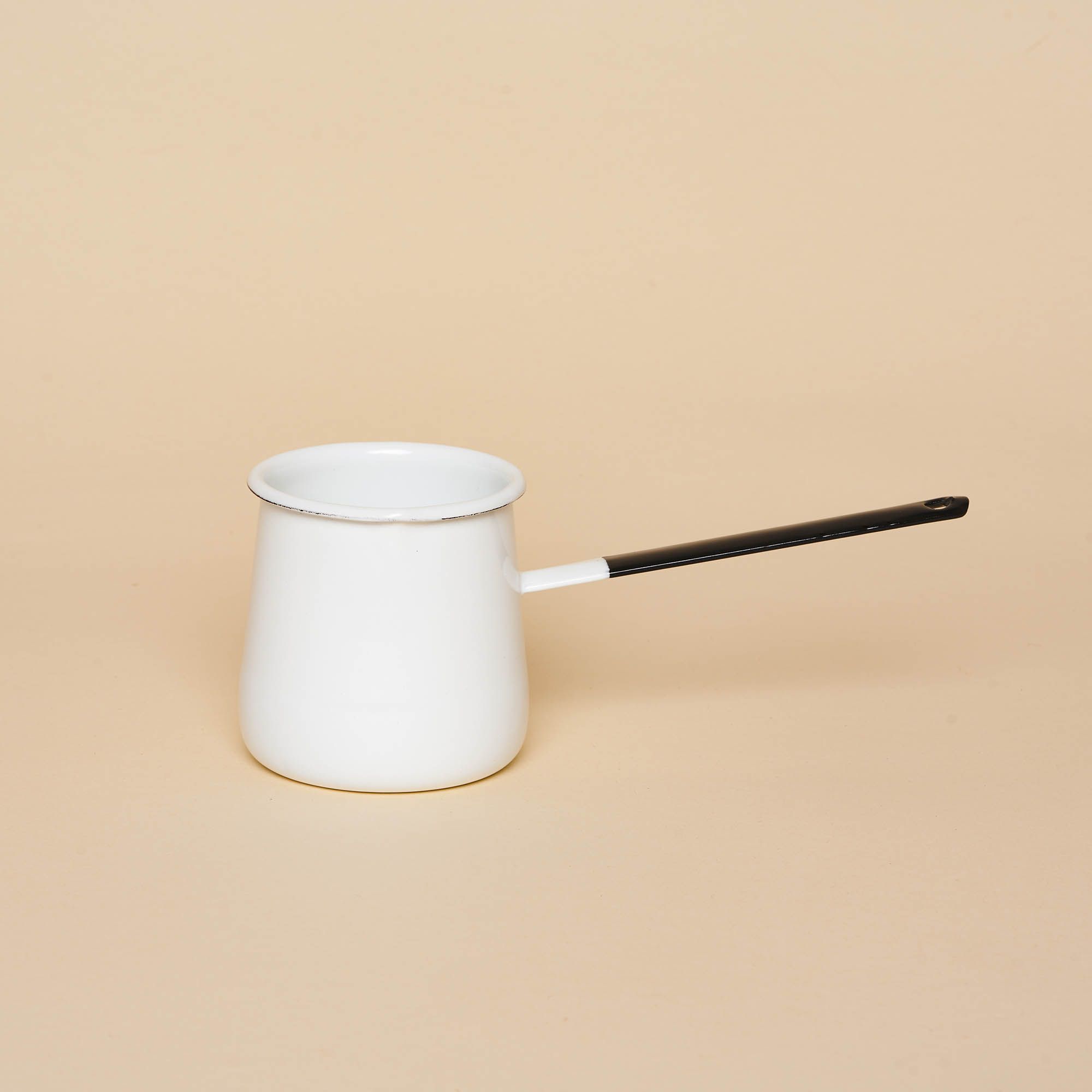 A small enamel pot that could fit in the palm of your hand