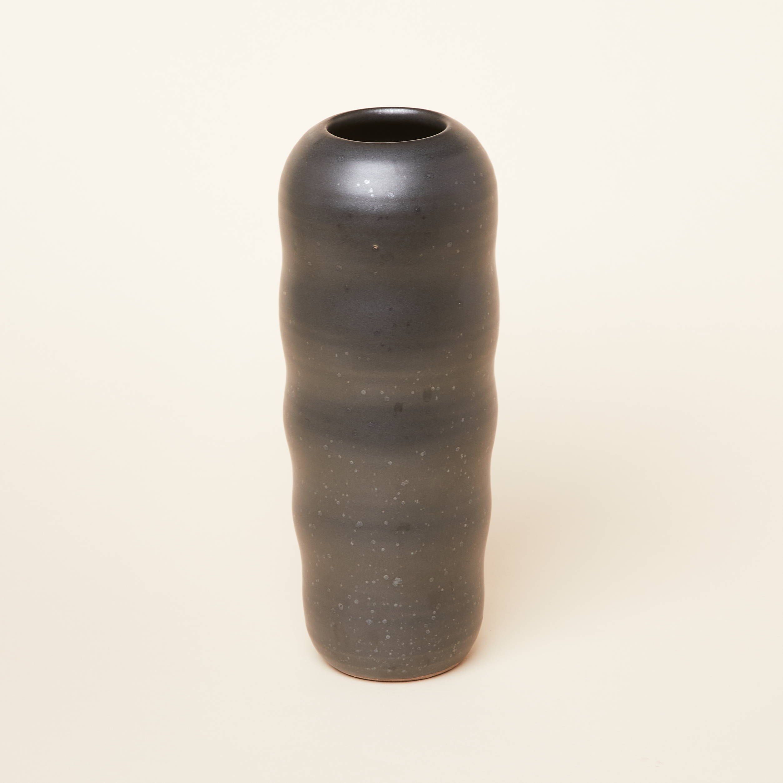A tall curvy vase in an earthy graphite color